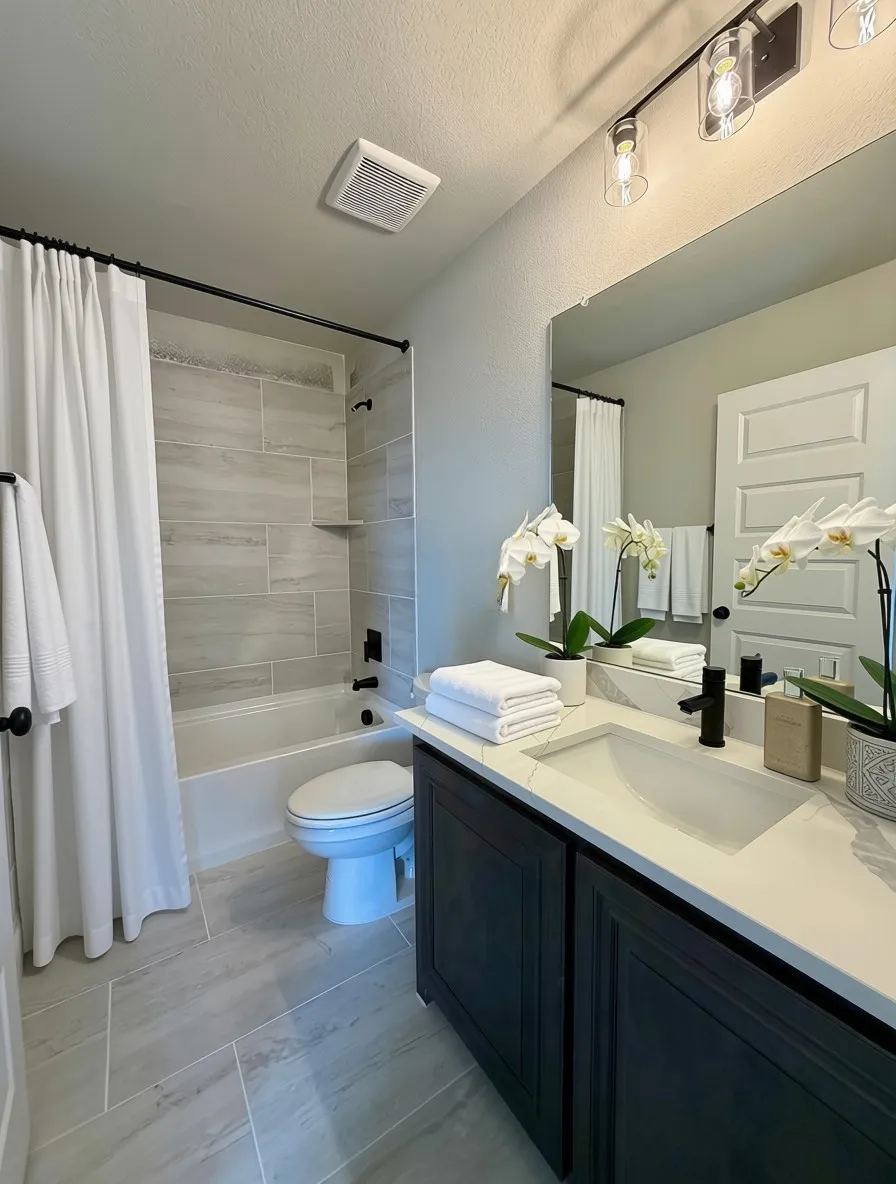 Bath 2 with quartz counters, slate grey cabinets, and 12x24 tile