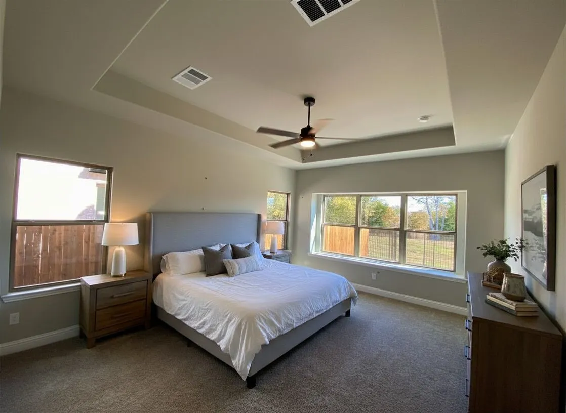 Master bedroom with tray ceiling, fan, and window seat