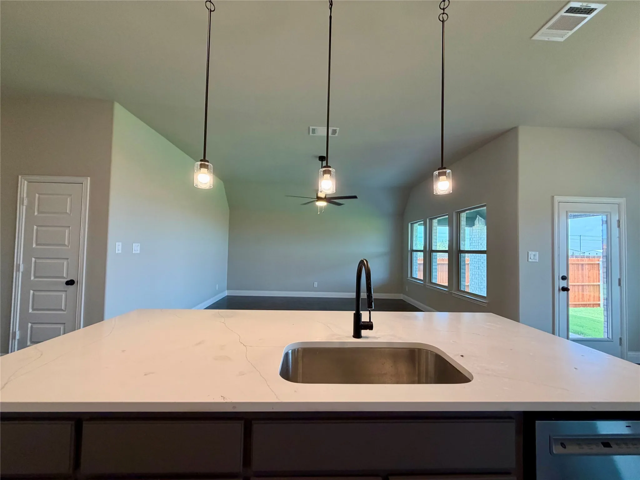 Large Grey kitchen island features a single basin stainless sink and Matte Black faucet with extendable sprayer