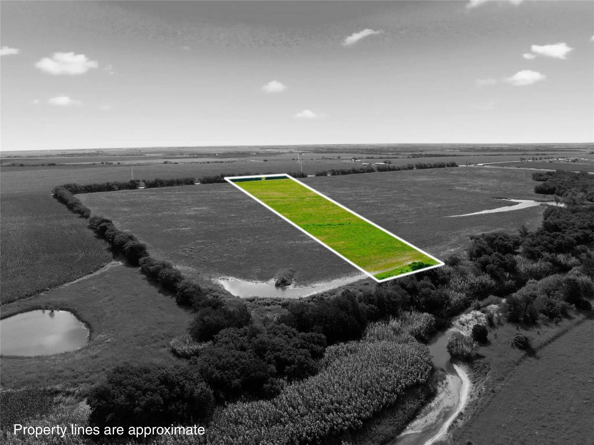 Expansive green parcel of land outlined in white, situated within a broader rural landscape