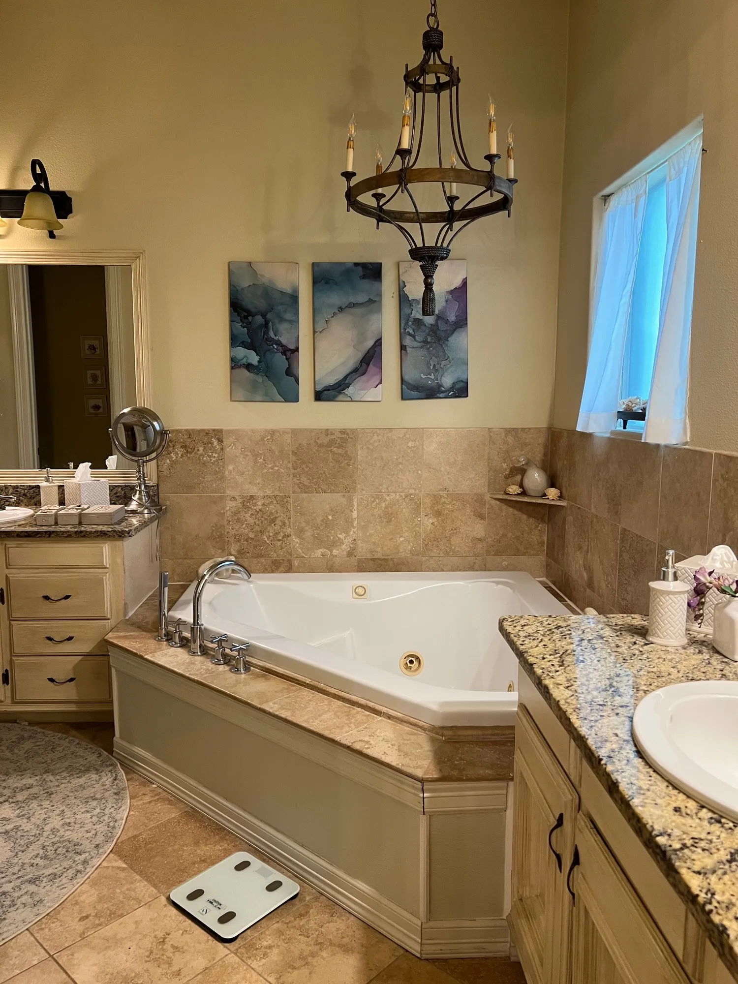 Corner soaking tub with jets, set within a stone-tiled surround