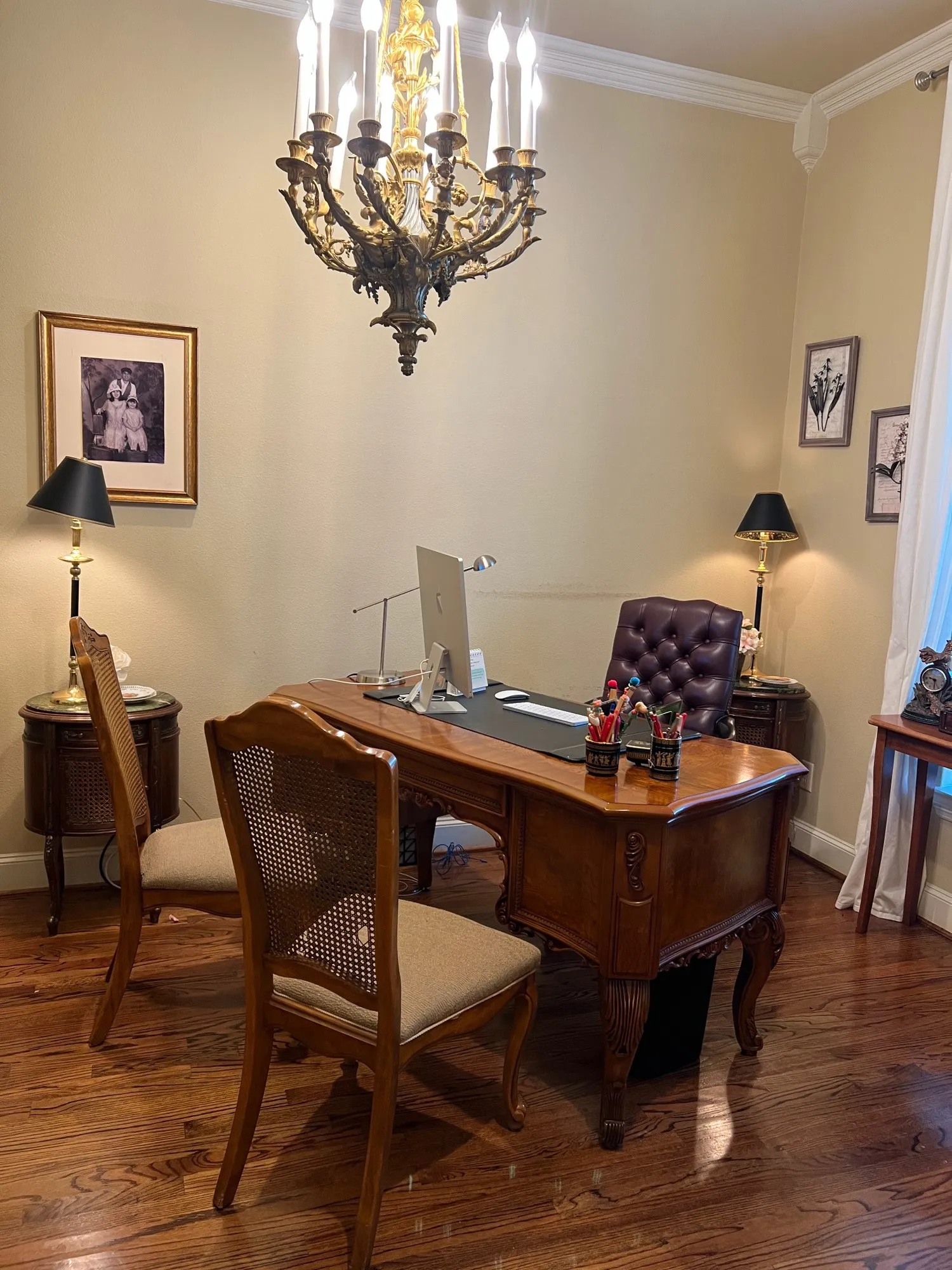 Formal room featuring an ornate brass chandelier, crown molding, a decorative corner corbel, and wood-finish flooring