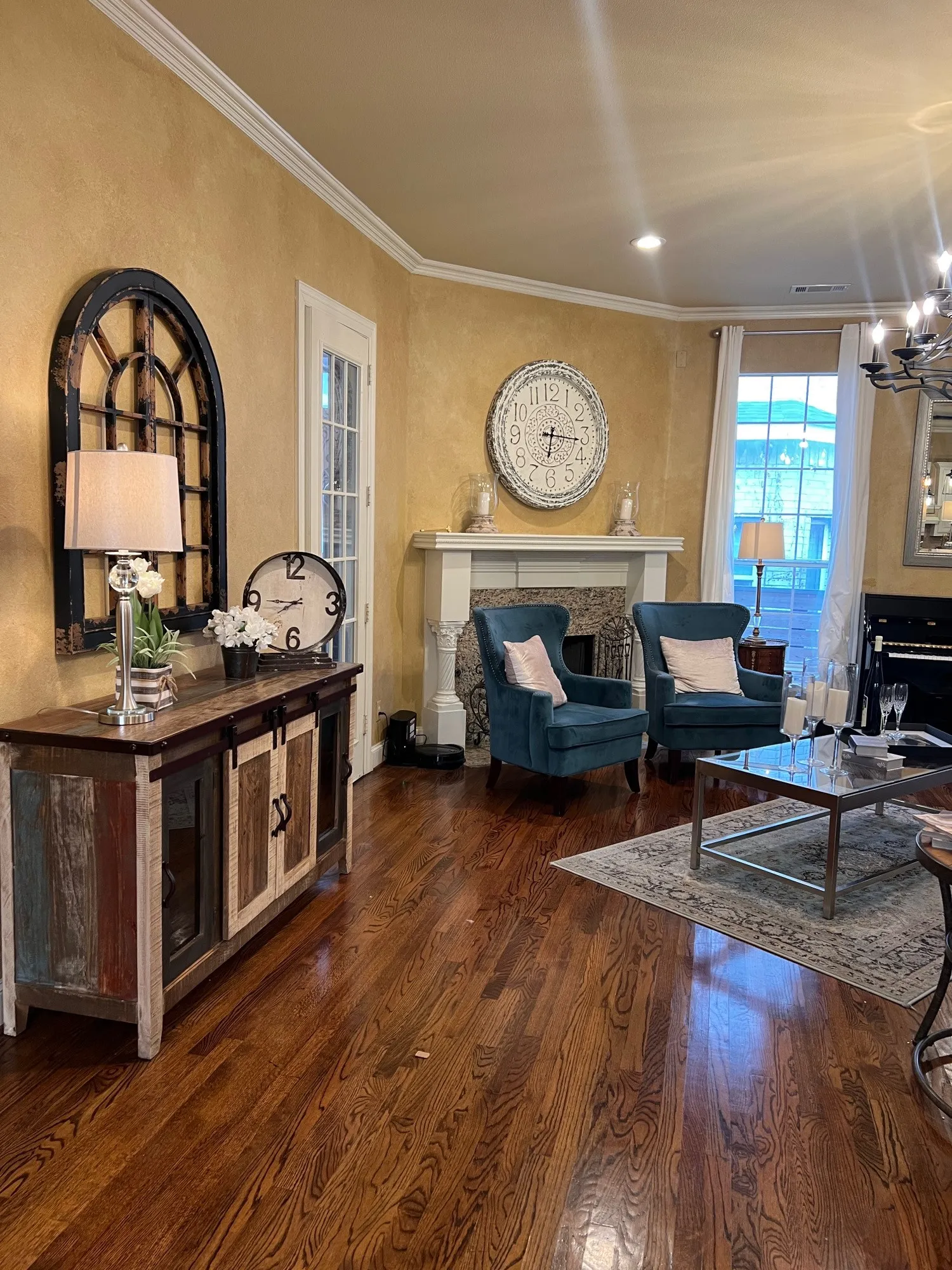 Hardwood flooring throughout featuring a decorative fireplace with a substantial mantel, crown molding, and recessed lighting