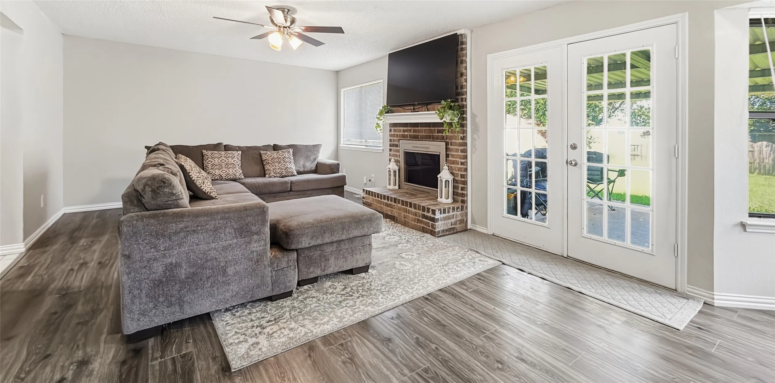 Living room with a wood burning fireplace and French Doors.