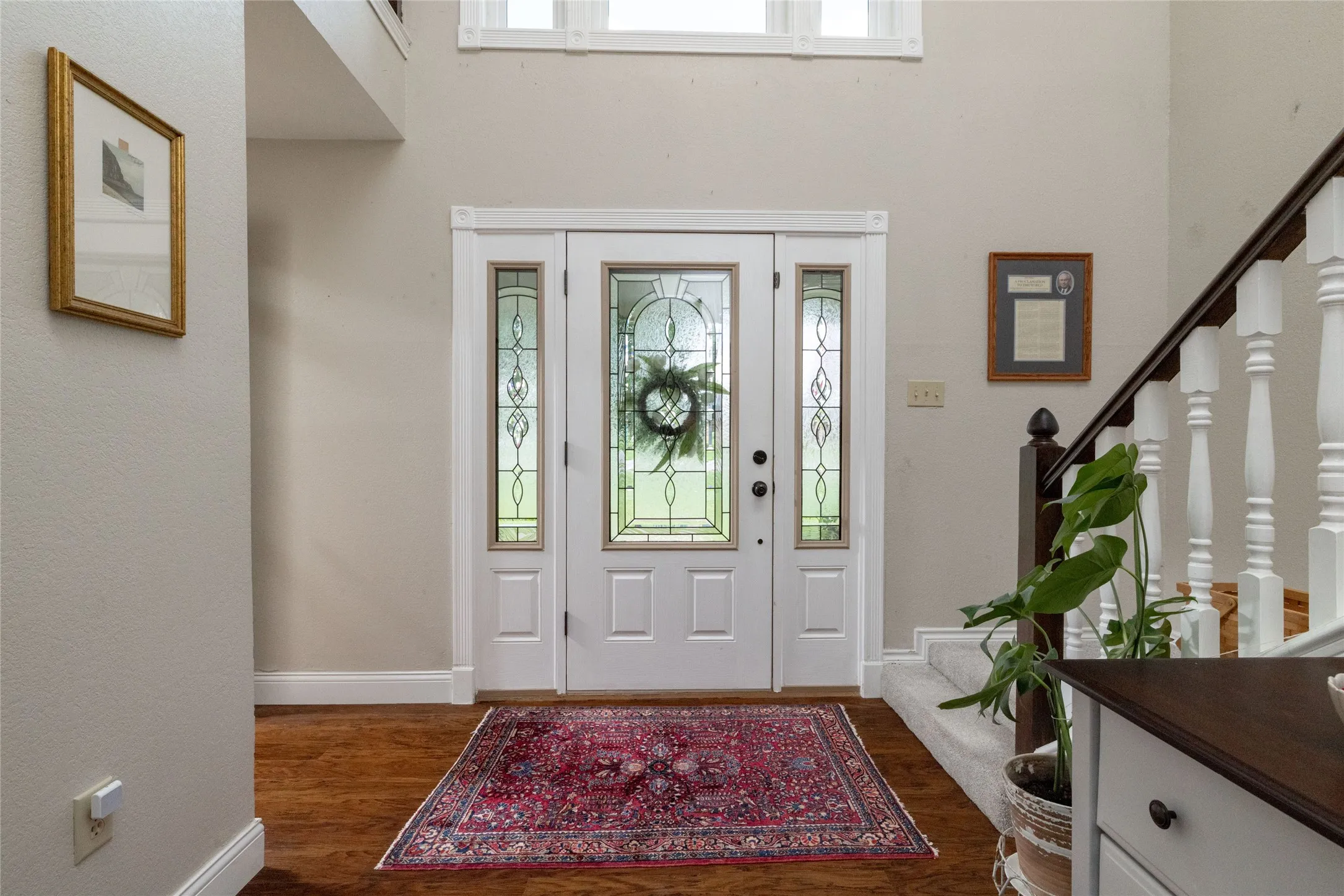 Entryway featuring a white door with decorative glass inserts, flanked by sidelights