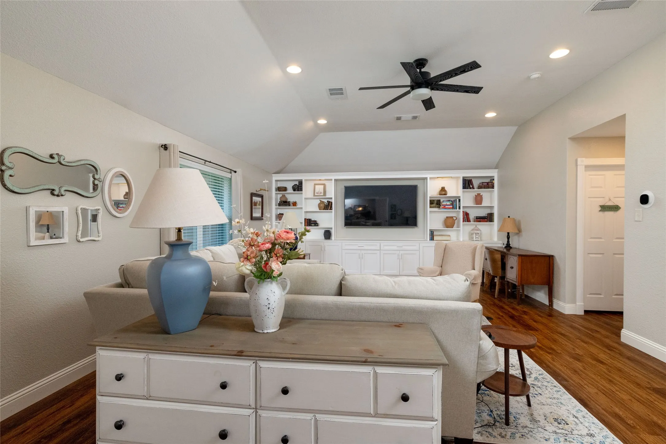 Living area featuring wood-finish flooring, recessed lighting, and a vaulted ceiling with a ceiling fan