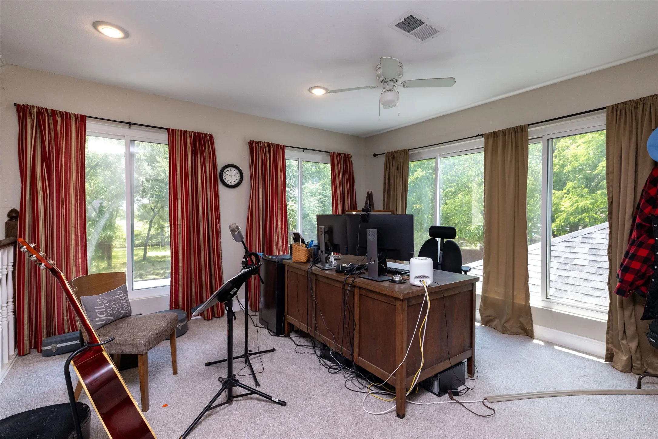 Carpeted room with a ceiling fan, recessed lighting, and multiple windows providing ambient light