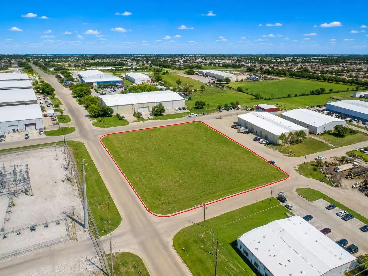 Expansive corner lot featuring a flat, grass-covered terrain