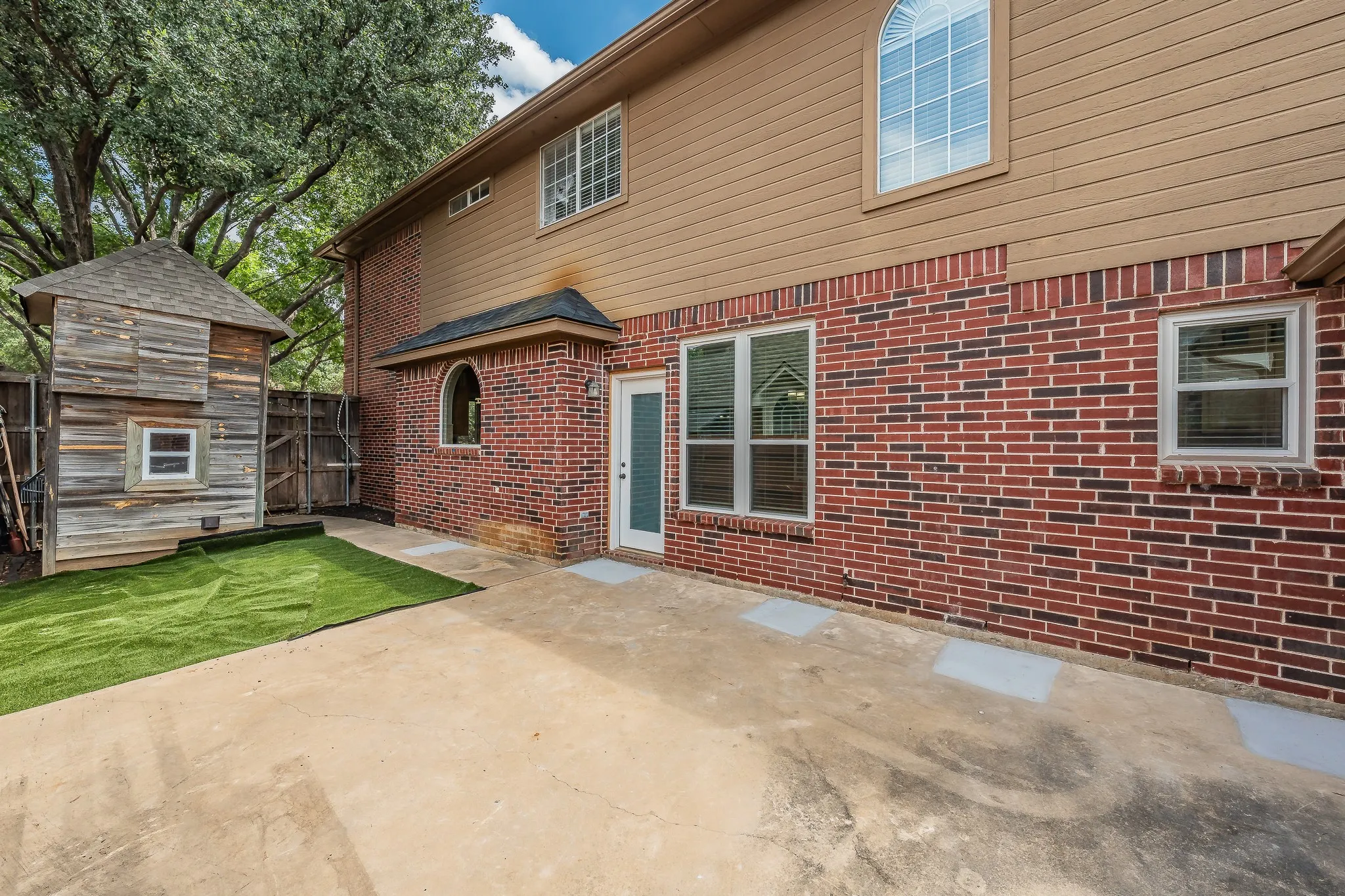 Rear exterior featuring multi-toned brick and horizontal siding