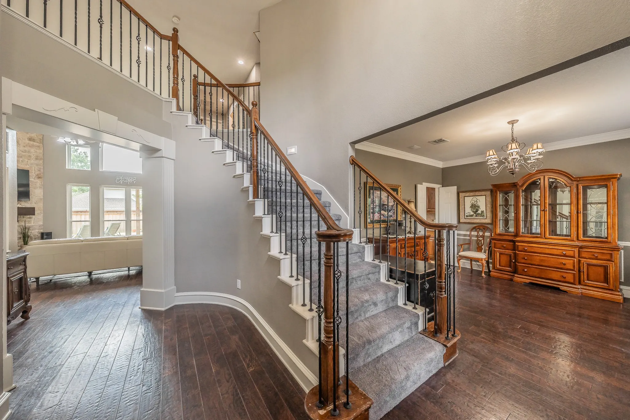 Grand foyer featuring a curved staircase with wrought iron balusters and wood-finish handrail