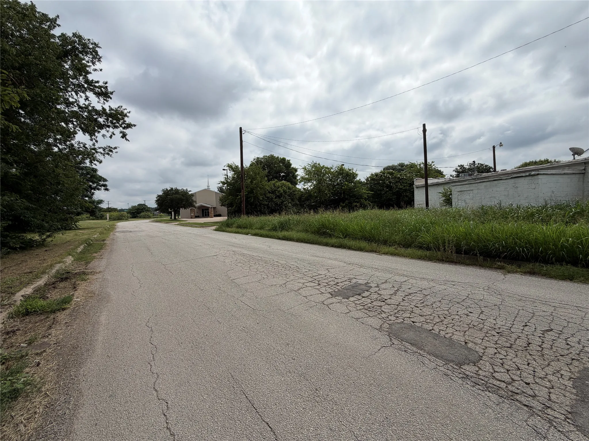Expansive undeveloped land featuring mature trees and established perimeter fencing