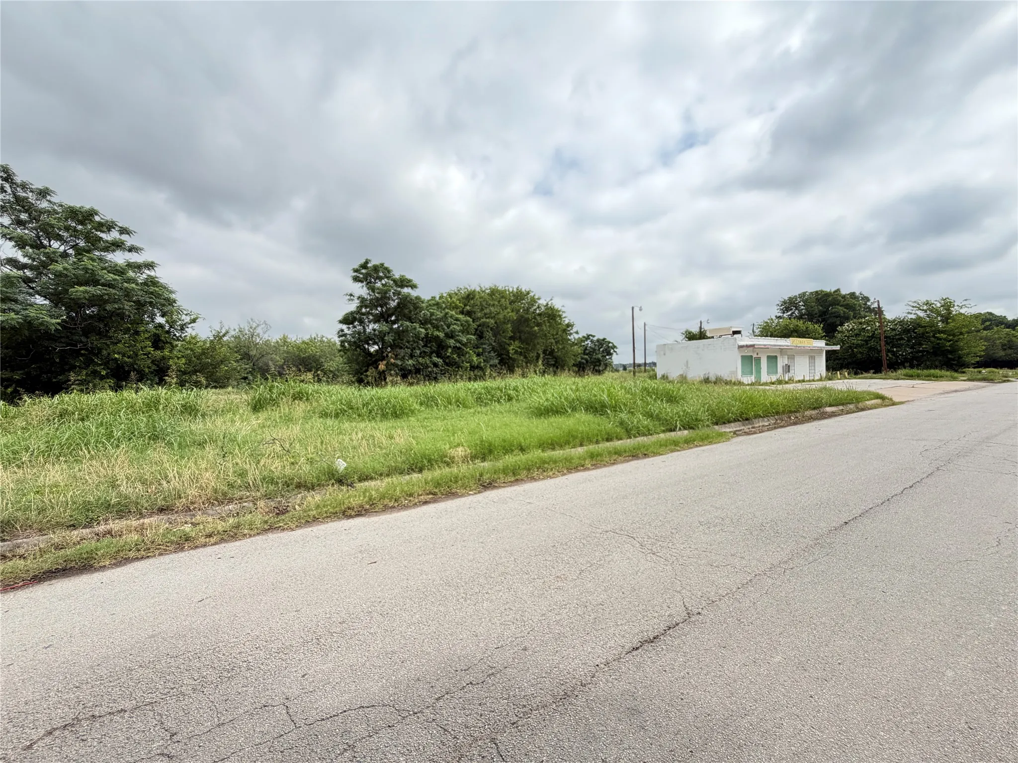 Expansive lot featuring a single-story commercial structure with a white stucco facade and multiple windows