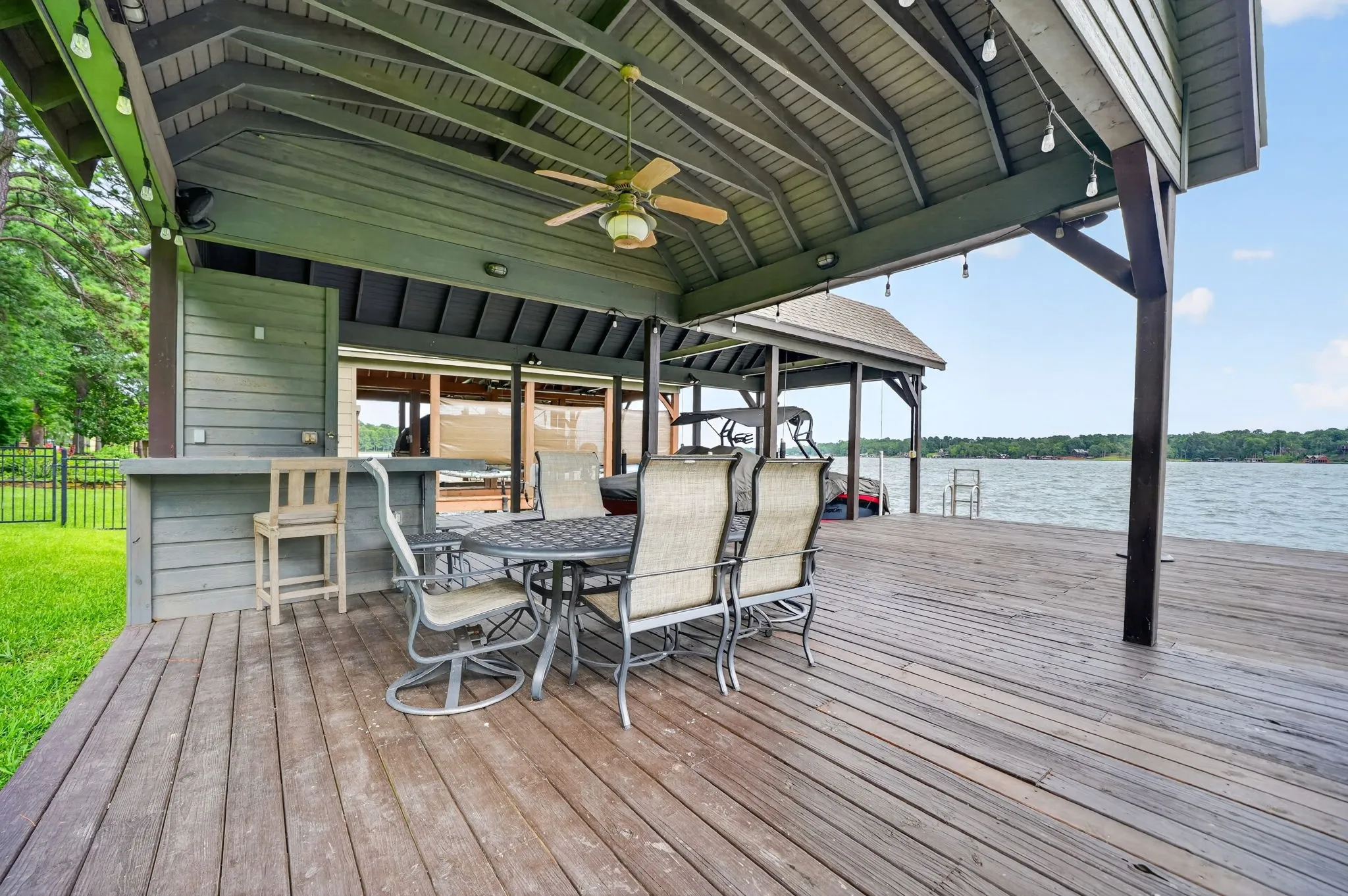 Expansive wooden dock featuring a covered patio, built-in bar, and direct water access