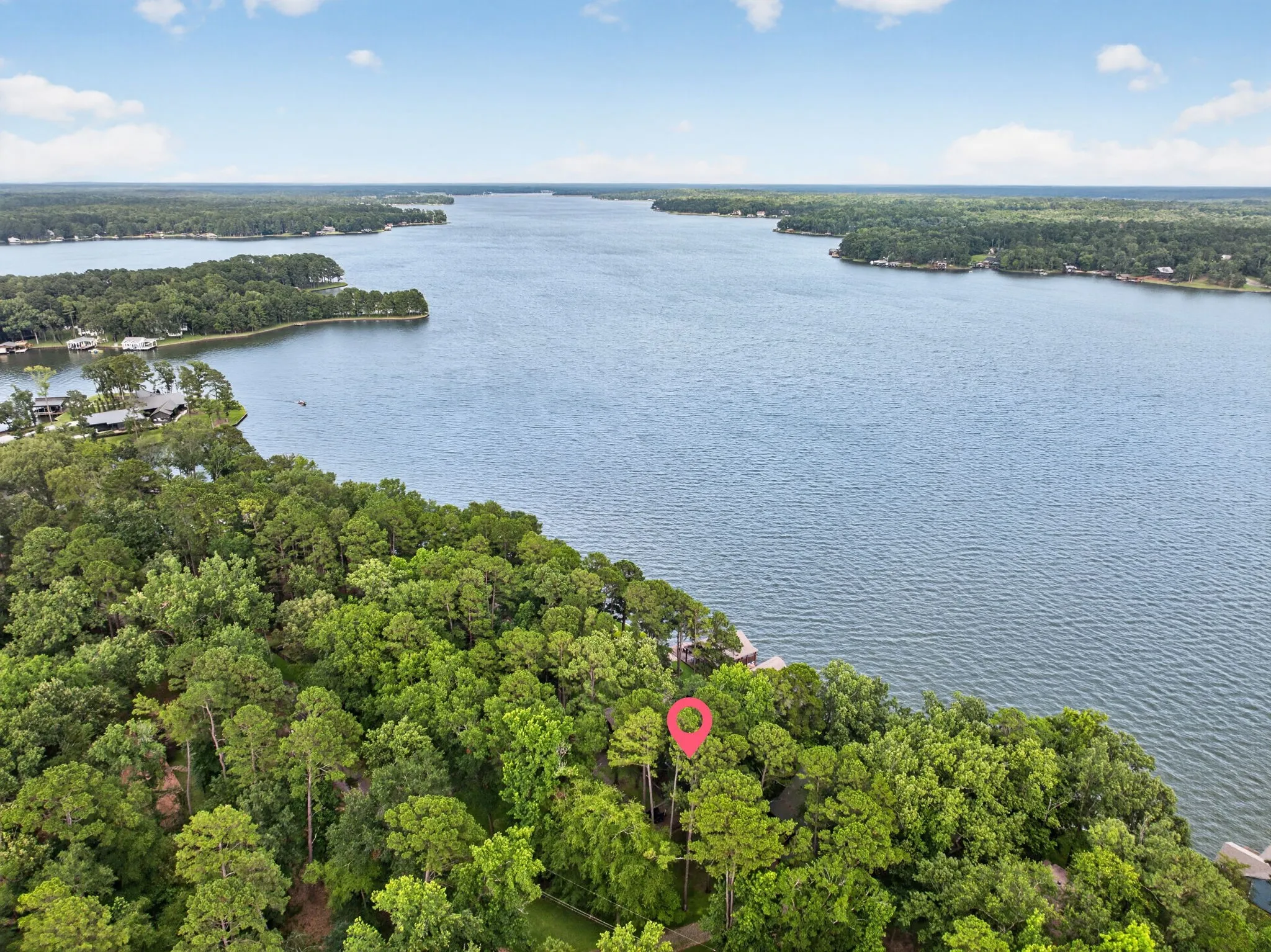 Expansive waterfront property featuring dense, mature tree coverage along a substantial body of water