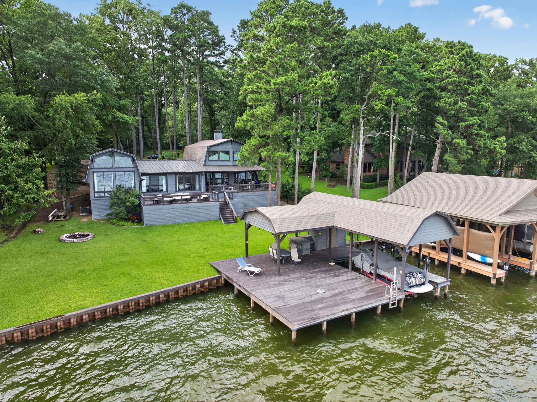 Waterfront property featuring an expansive multi-slip dock with covered boat storage