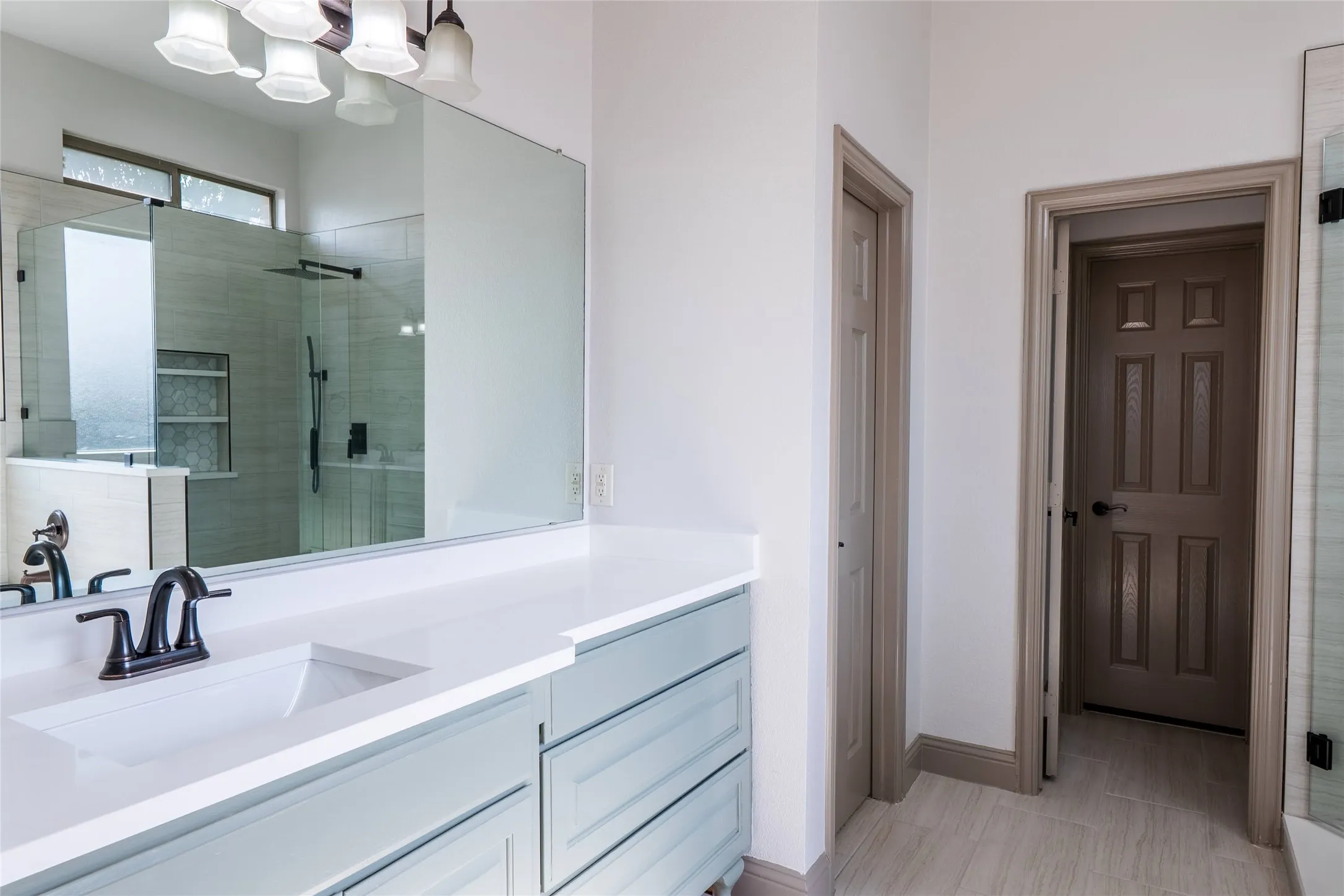 Bathroom featuring a dual-sink vanity with light blue cabinetry, a white countertop, and oil-rubbed bronze fixtures