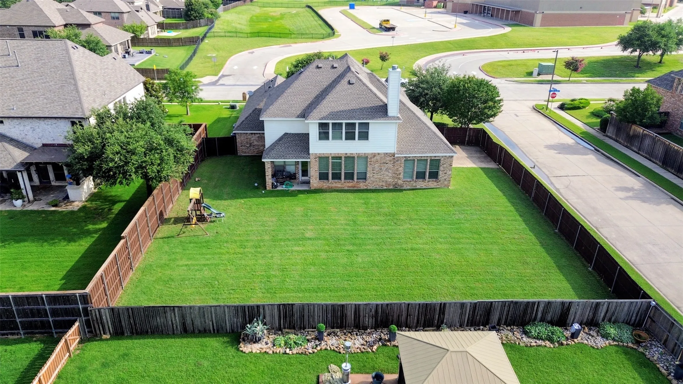 Two-story residence featuring a brick and siding exterior, multiple windows, and a shingled roof