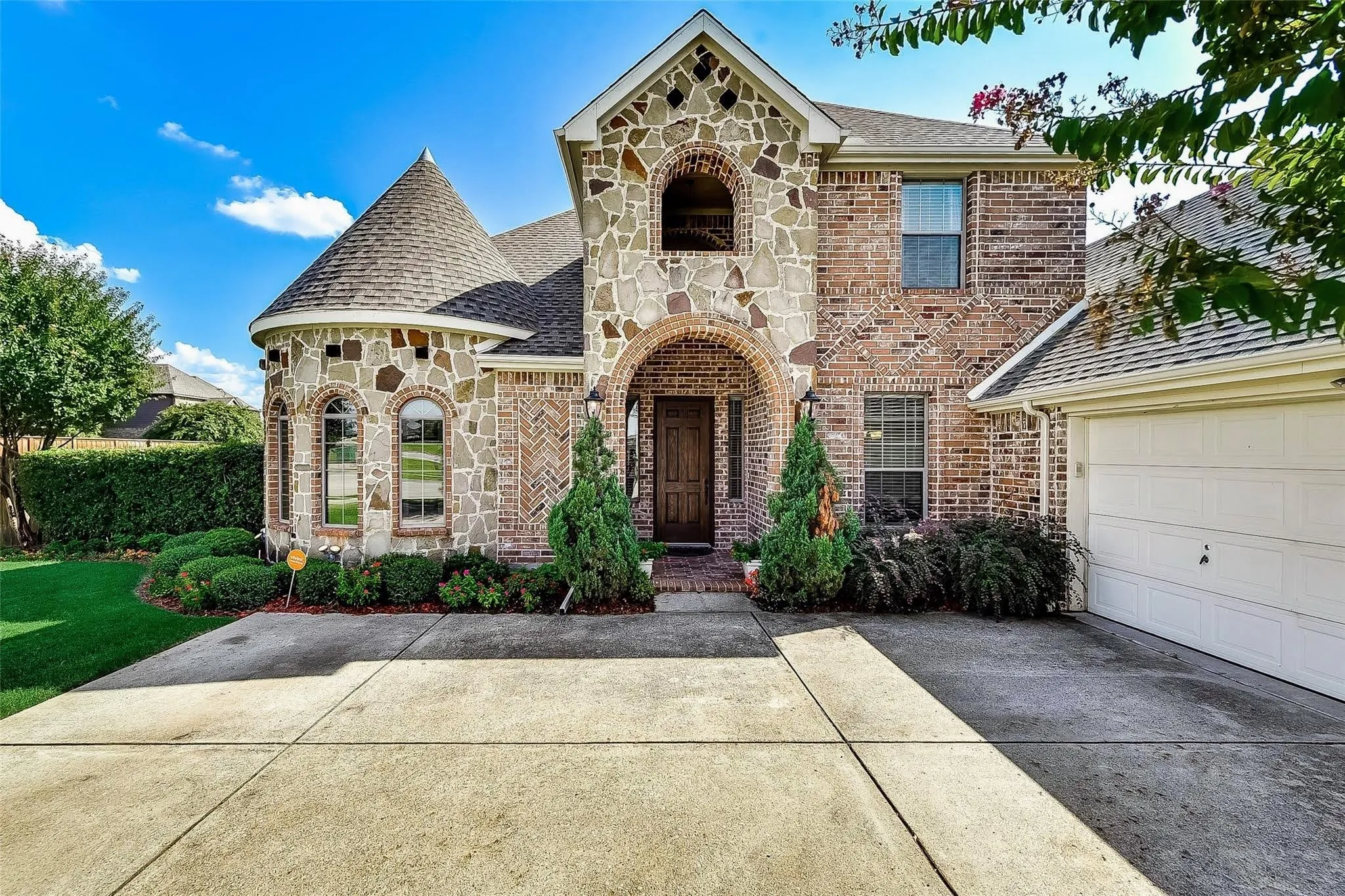 Stone and brick exterior featuring a prominent turretted section with arched windows