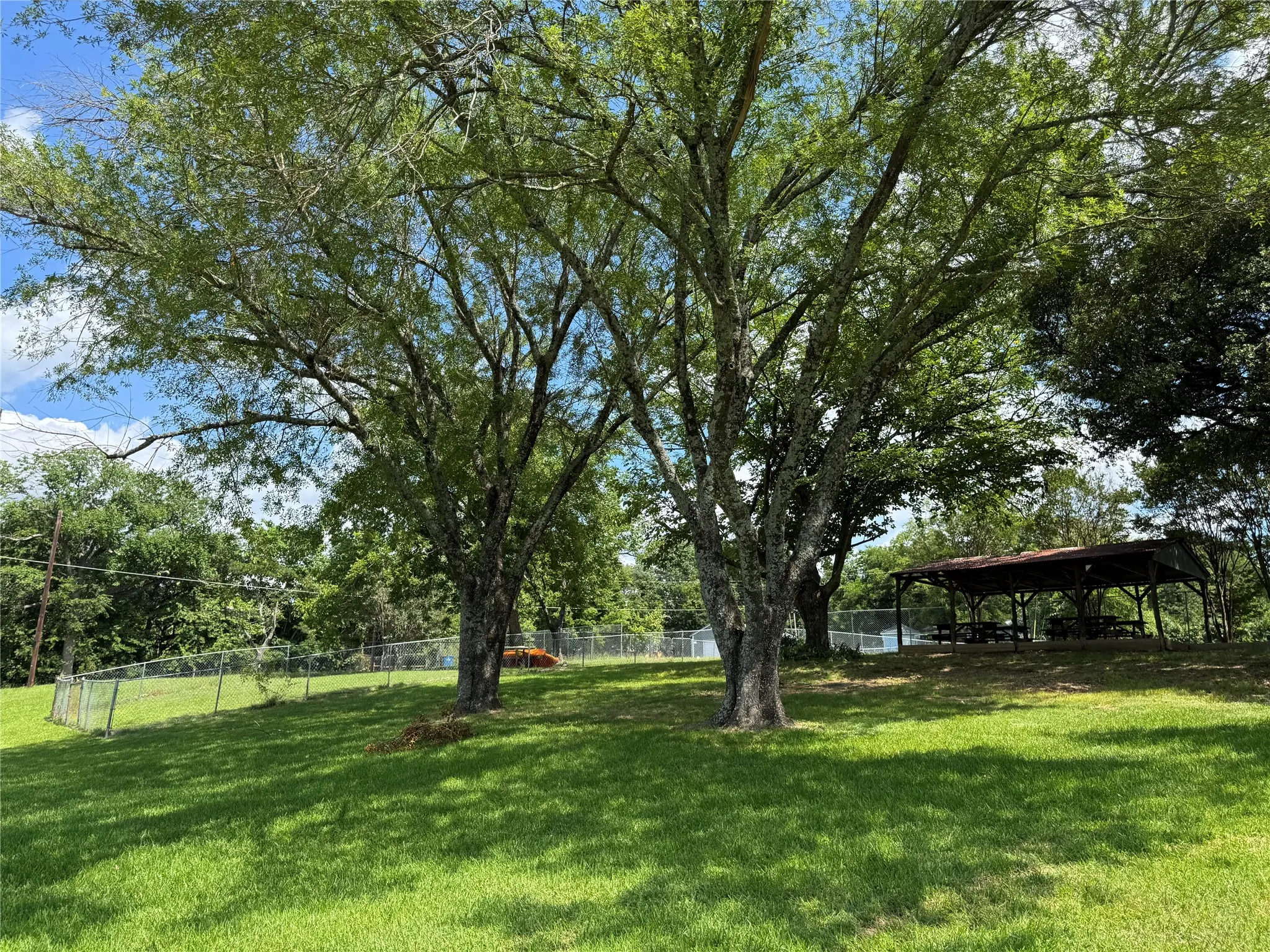 Expansive grassy area featuring mature trees providing shade at the HOA part of the property just a block away.