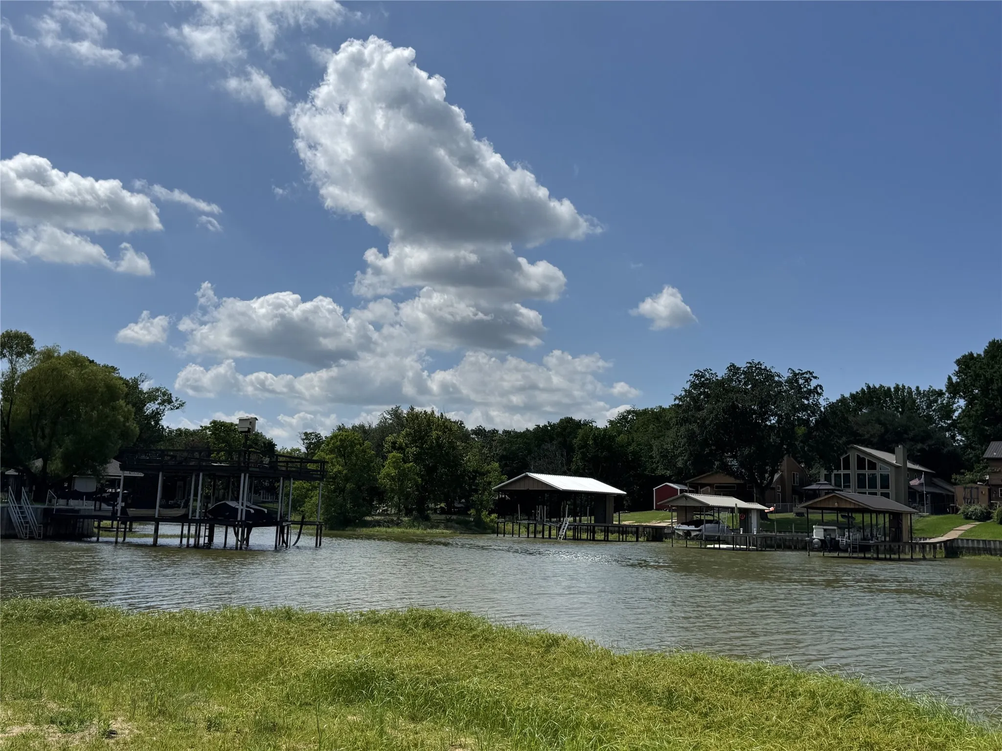Waterfront property featuring multiple private boat docks, mature trees, and a residential landscape just a block away.