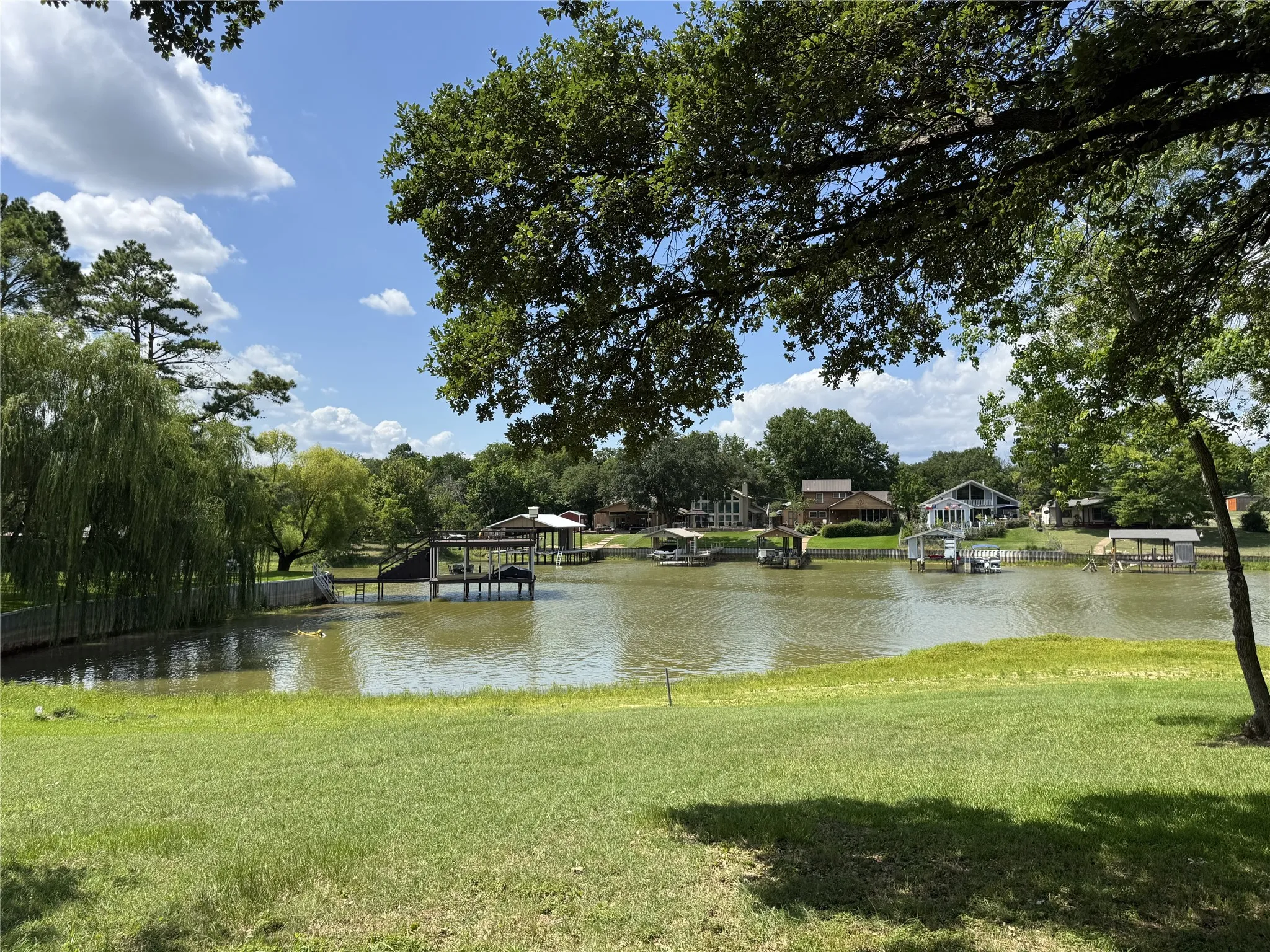 Expansive waterfront lawn with mature trees and a tranquil lake setting just a block away