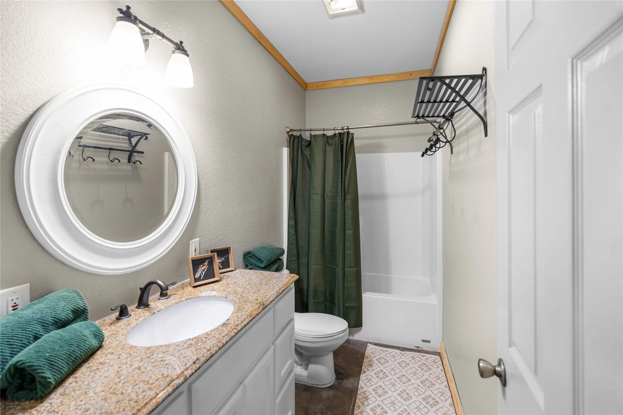 Bathroom featuring a white vanity with a speckled countertop, an undermount sink, and a dark bronze faucet
