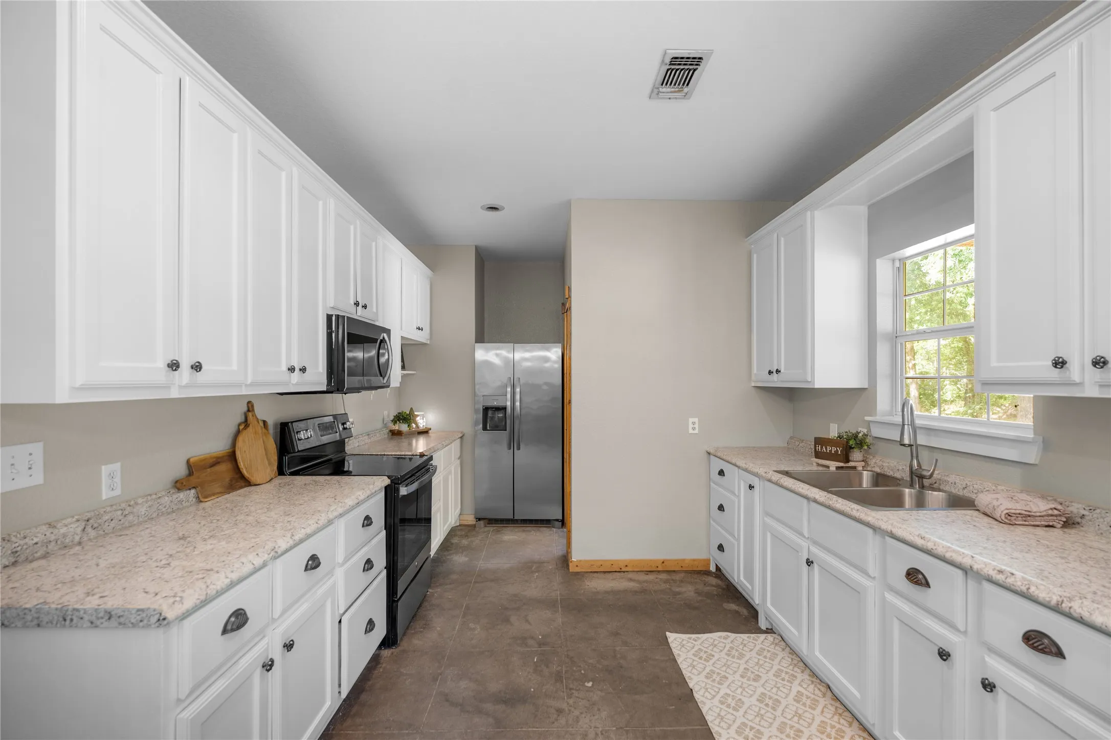 Kitchen featuring white cabinetry and light-toned countertops