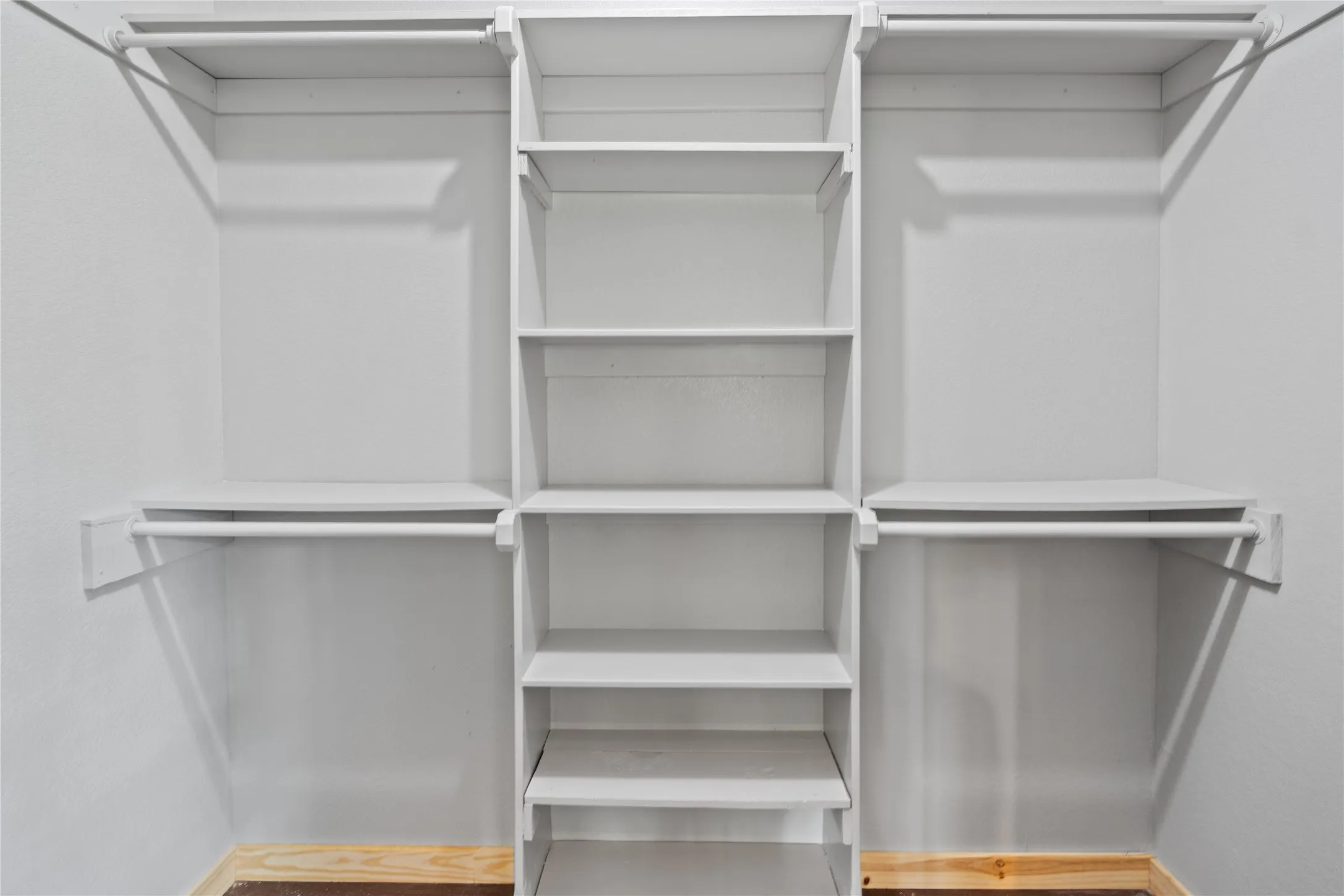 Built-in closet organization system featuring a central shelving unit and two distinct hanging sections