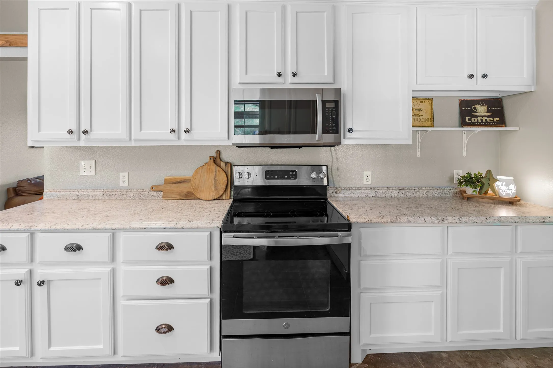 Kitchen featuring white shaker-style cabinetry, light-colored countertops, stainless steel appliances, and a built-in microwave