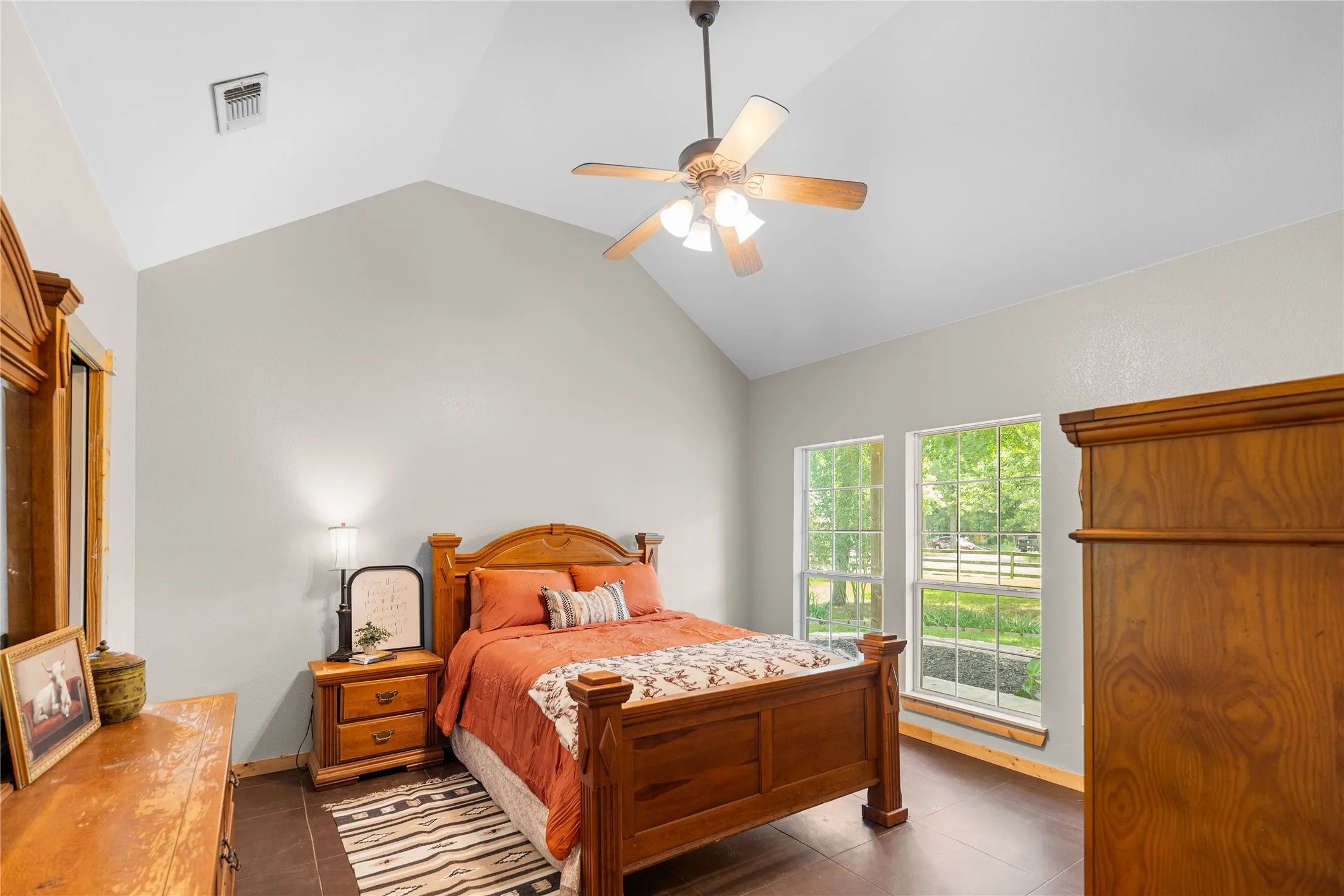 Vaulted ceilings featuring a ceiling fan with light fixture