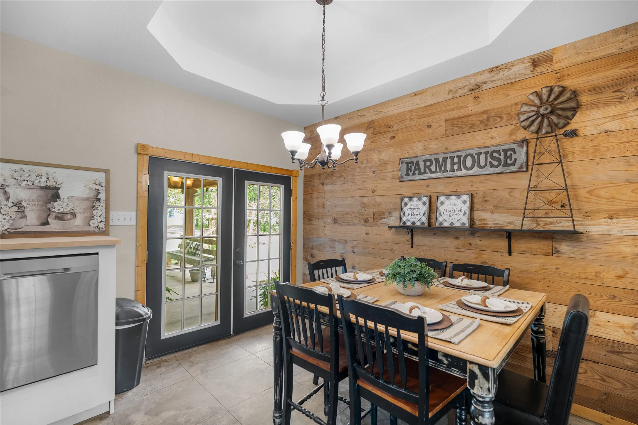 Dining area featuring a wood-paneled accent wall, coffered ceiling, and a chandelier with glass​​‌​​​​‌​​‌‌​‌‌​​​‌‌​‌​‌​‌​​​‌​​ shades