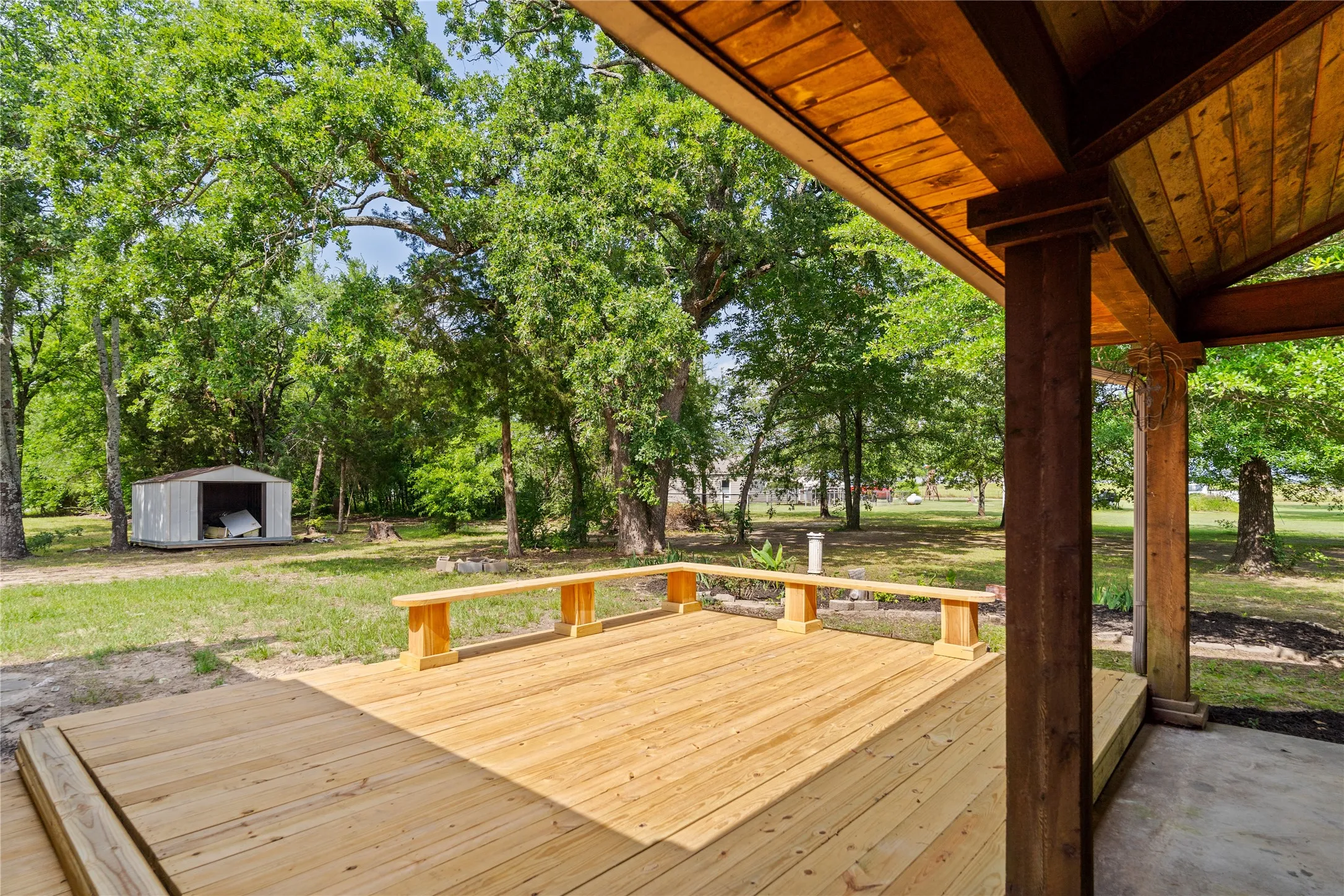Expansive wood deck with integrated benches, featuring a partial covered area