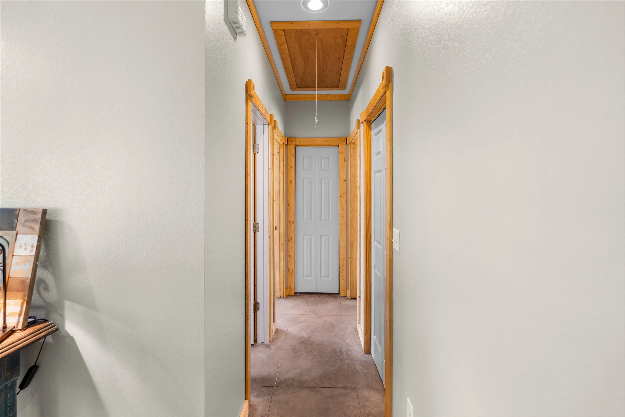 Hallway featuring light-toned walls, wood-finish trim, and recessed lighting