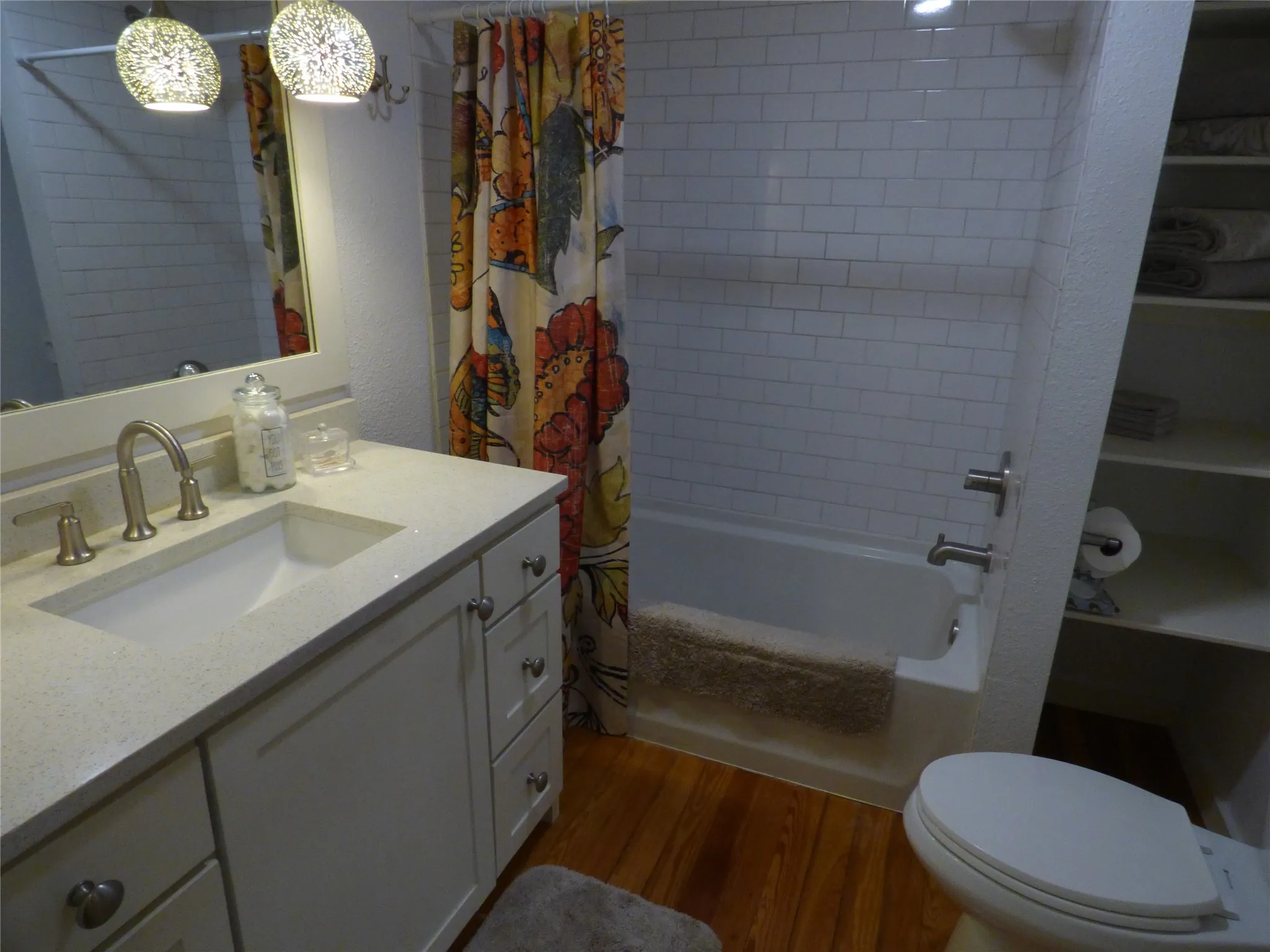 White vanity with integrated rectangular sink and brushed nickel faucet