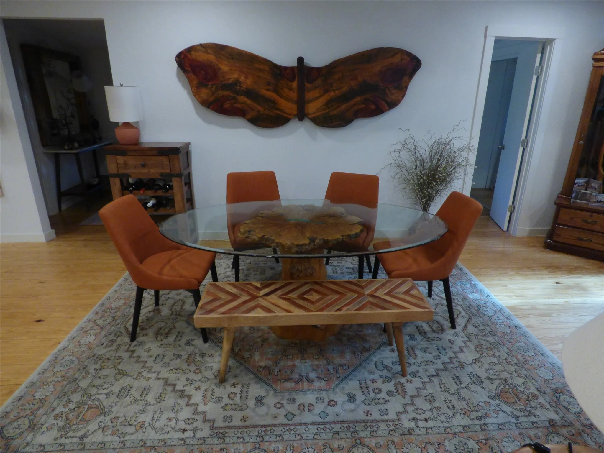 Spacious room featuring wood-finish flooring, a light-toned area rug, and a built-in wall art installation
