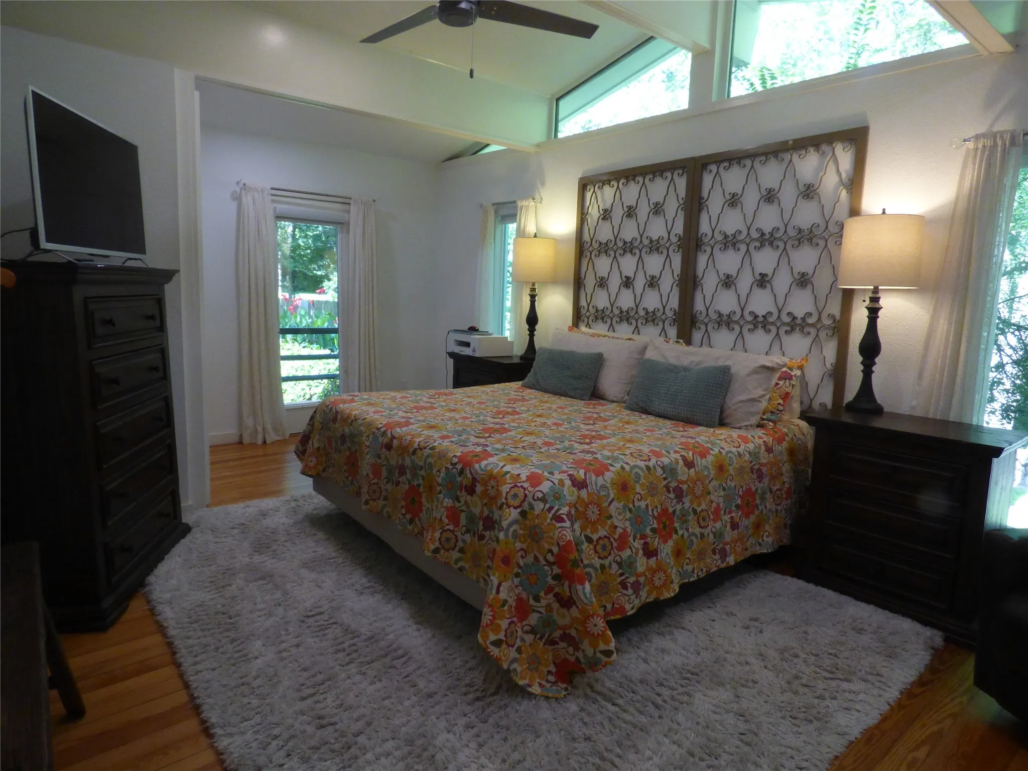 Room featuring high vaulted ceilings, clerestory windows, and hardwood flooring