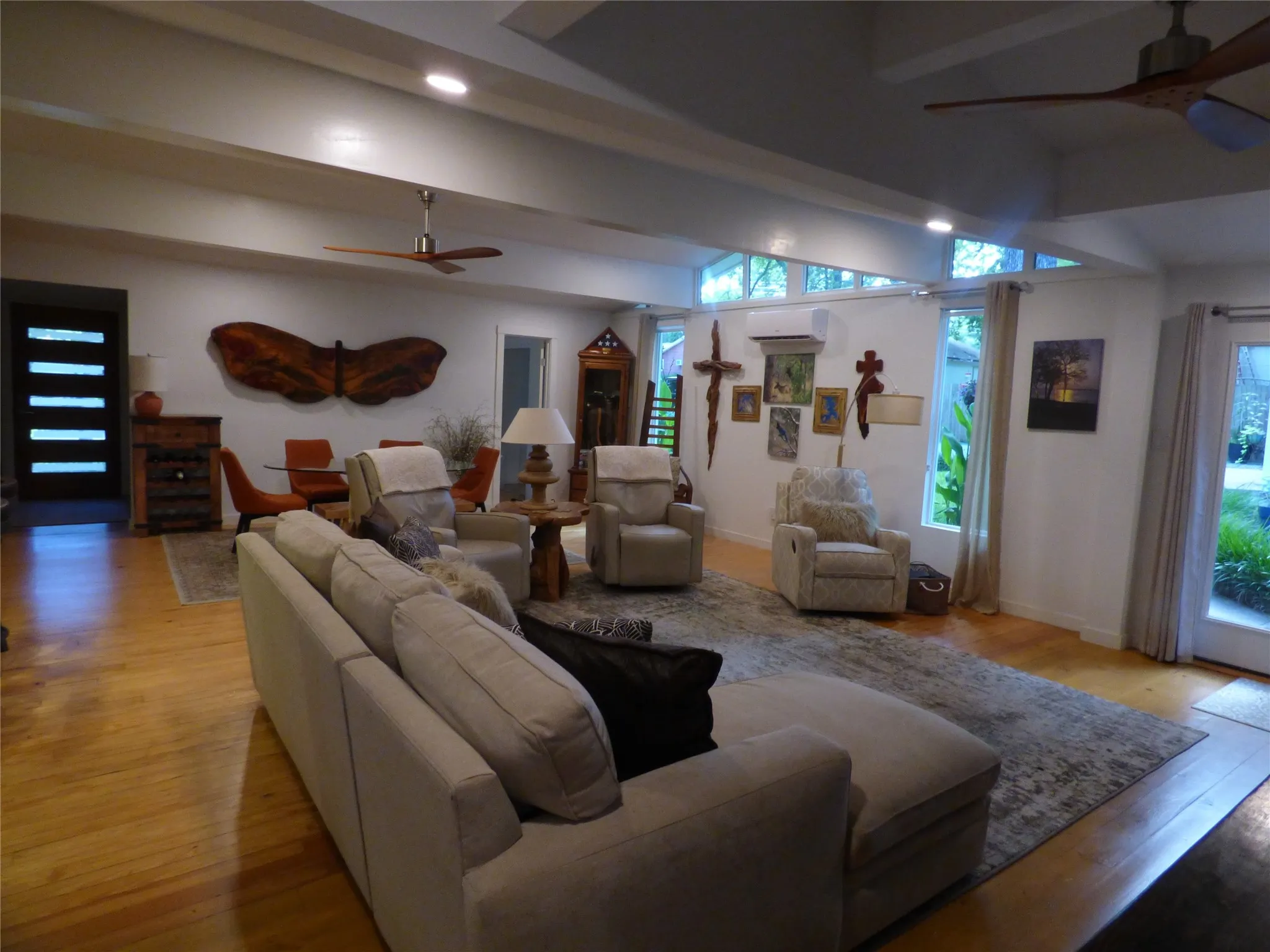 Spacious living area featuring exposed ceiling beams, recessed lighting, and wood-finish flooring