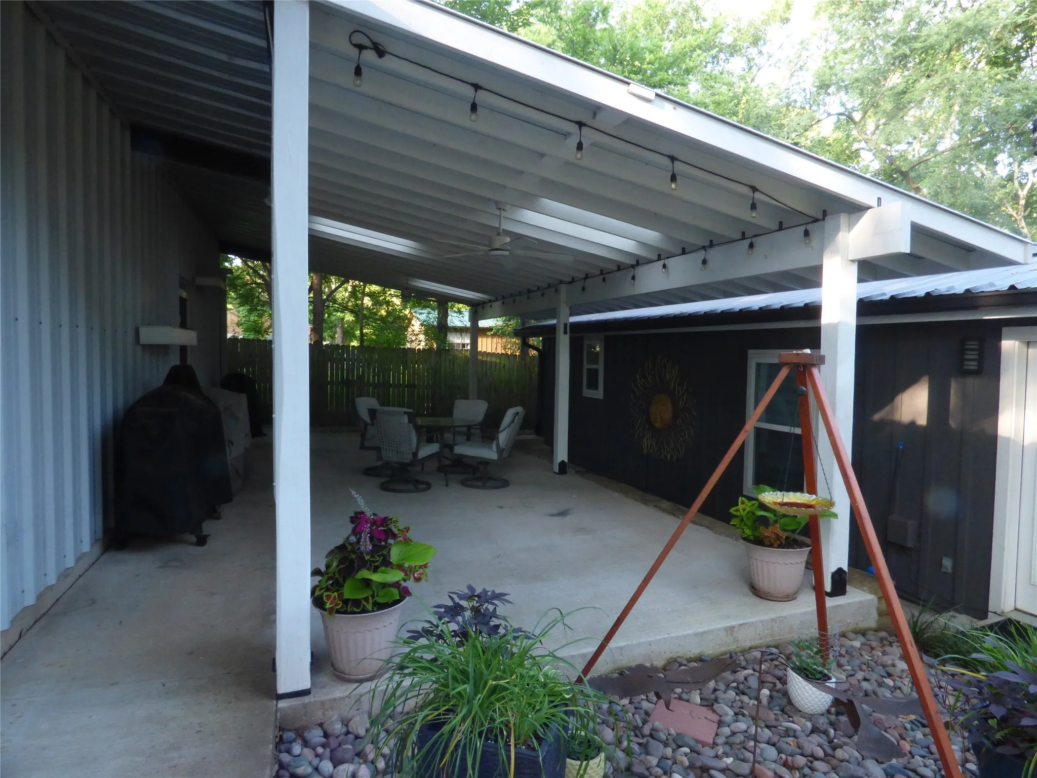 Covered concrete patio with white support beams