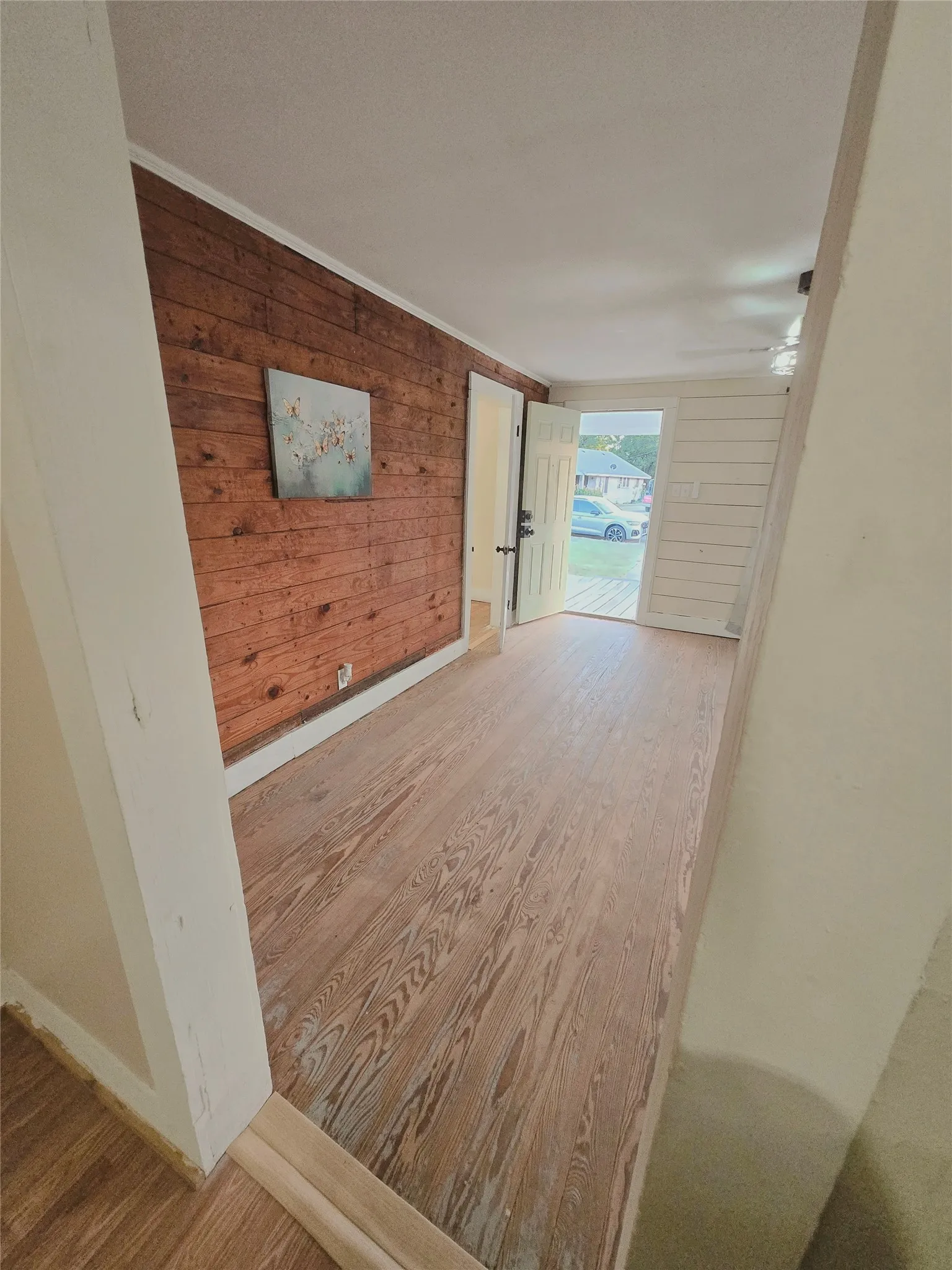 Natural wood flooring extends through this welcoming entry, offering a glimpse of the outdoors.