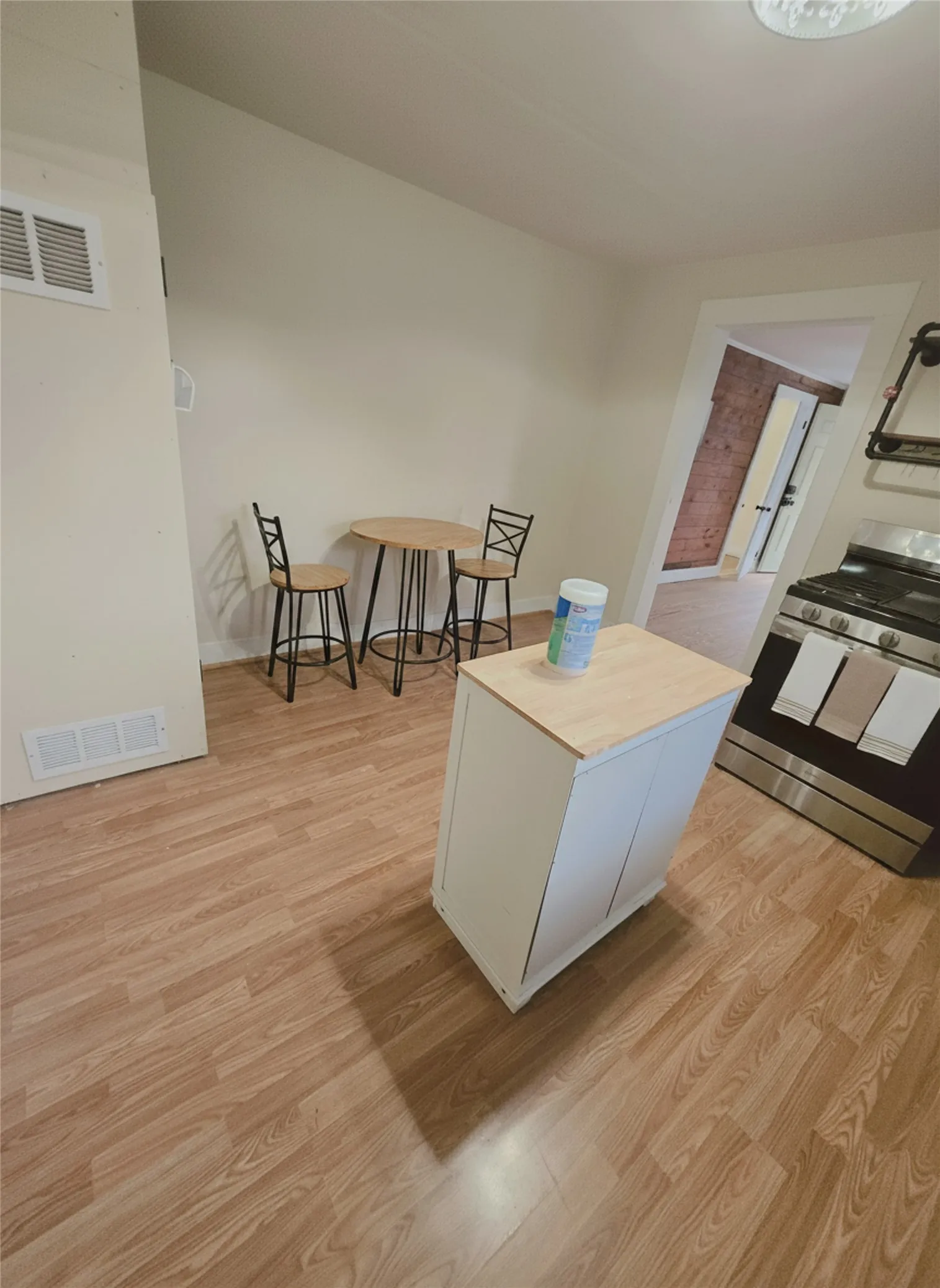 Laminate flooring graces this welcoming kitchen and dining area. DIGITAL STAGING