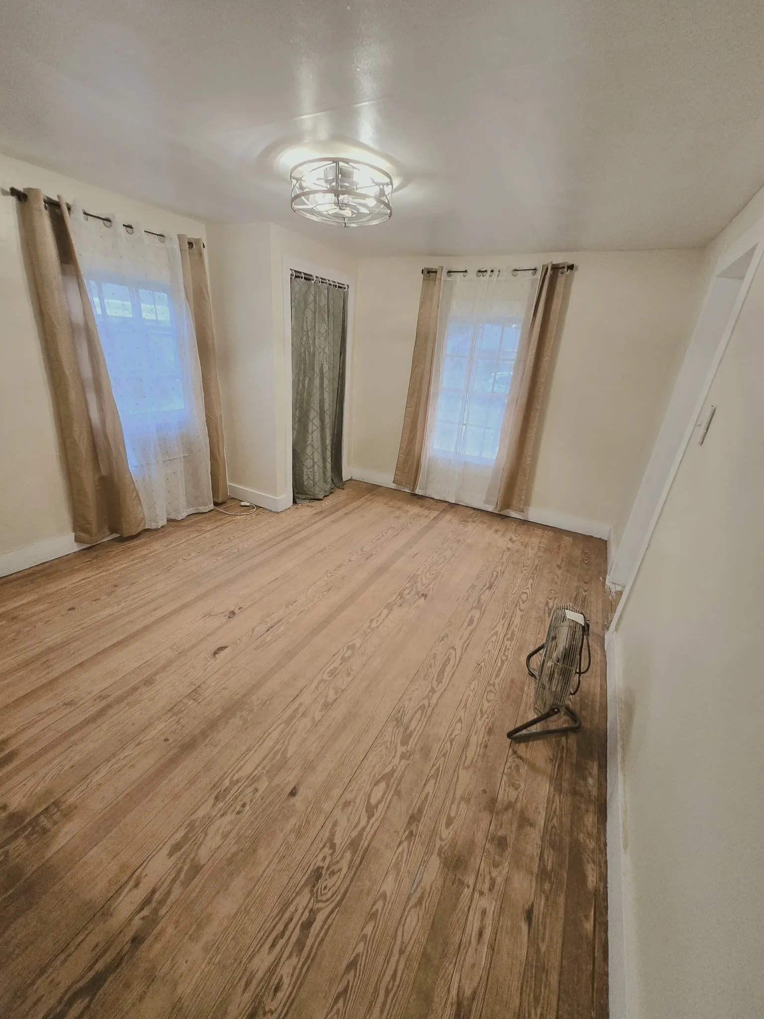 Natural wood flooring complements the airy feel of this well-lit living space.