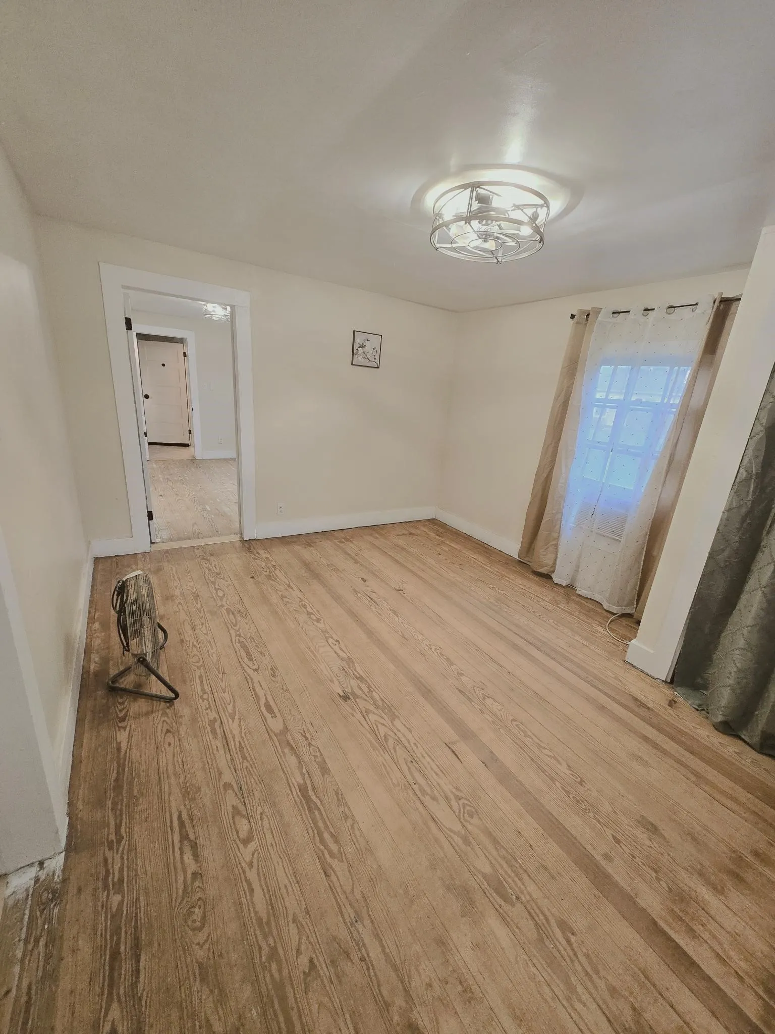 Hardwood floors and a bright window elevate this versatile room, ready for your personal touch.