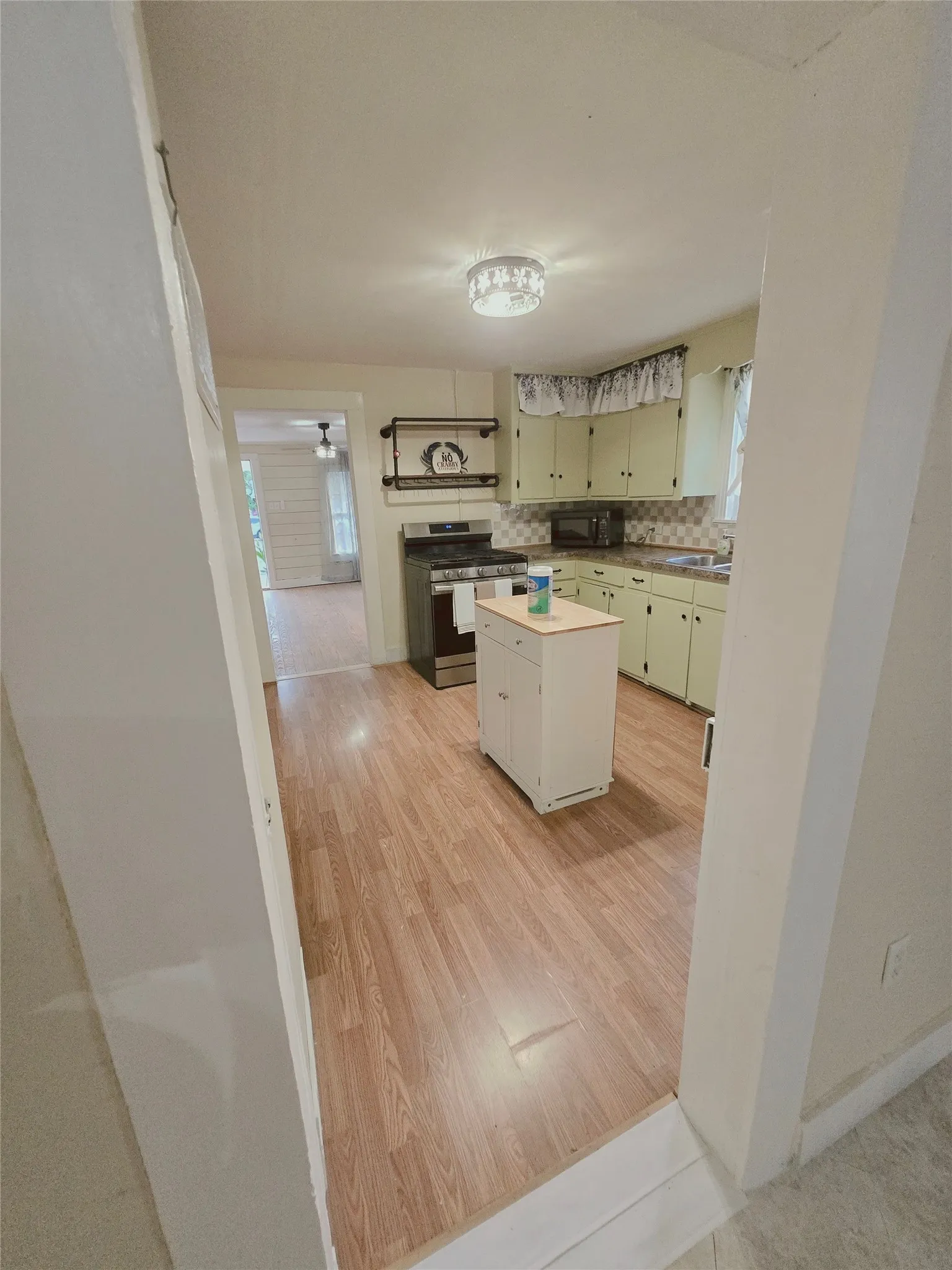 Warm wood flooring extends throughout this well-maintained kitchen.