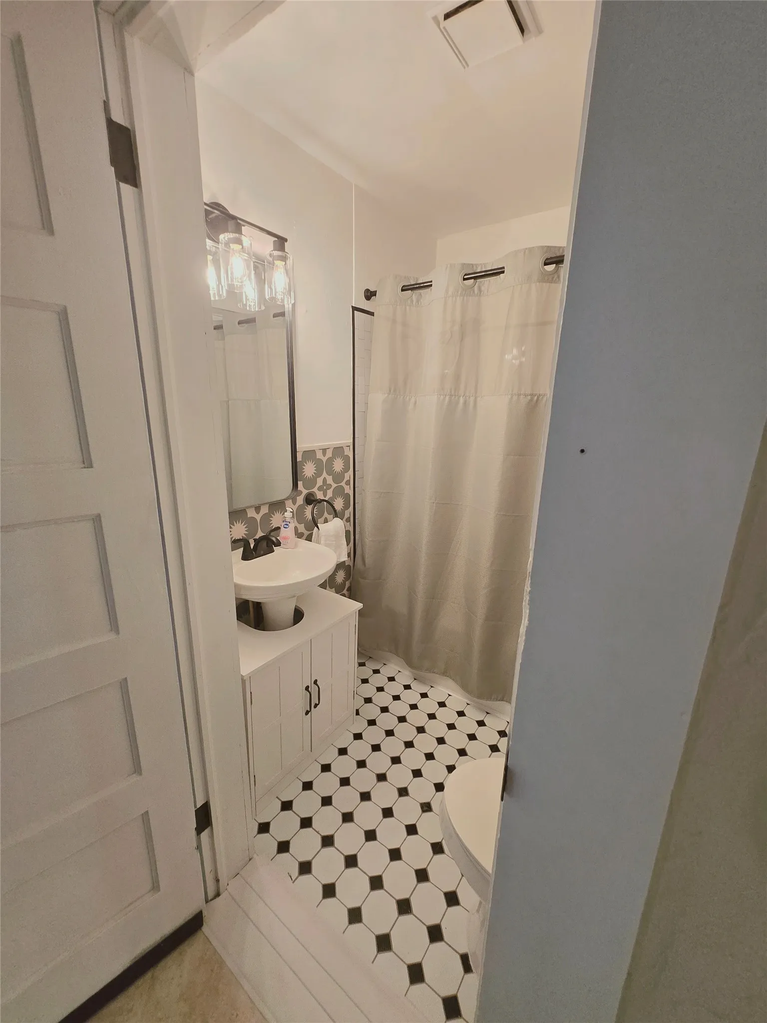 A well-appointed bathroom with striking black and white hexagonal tile flooring.