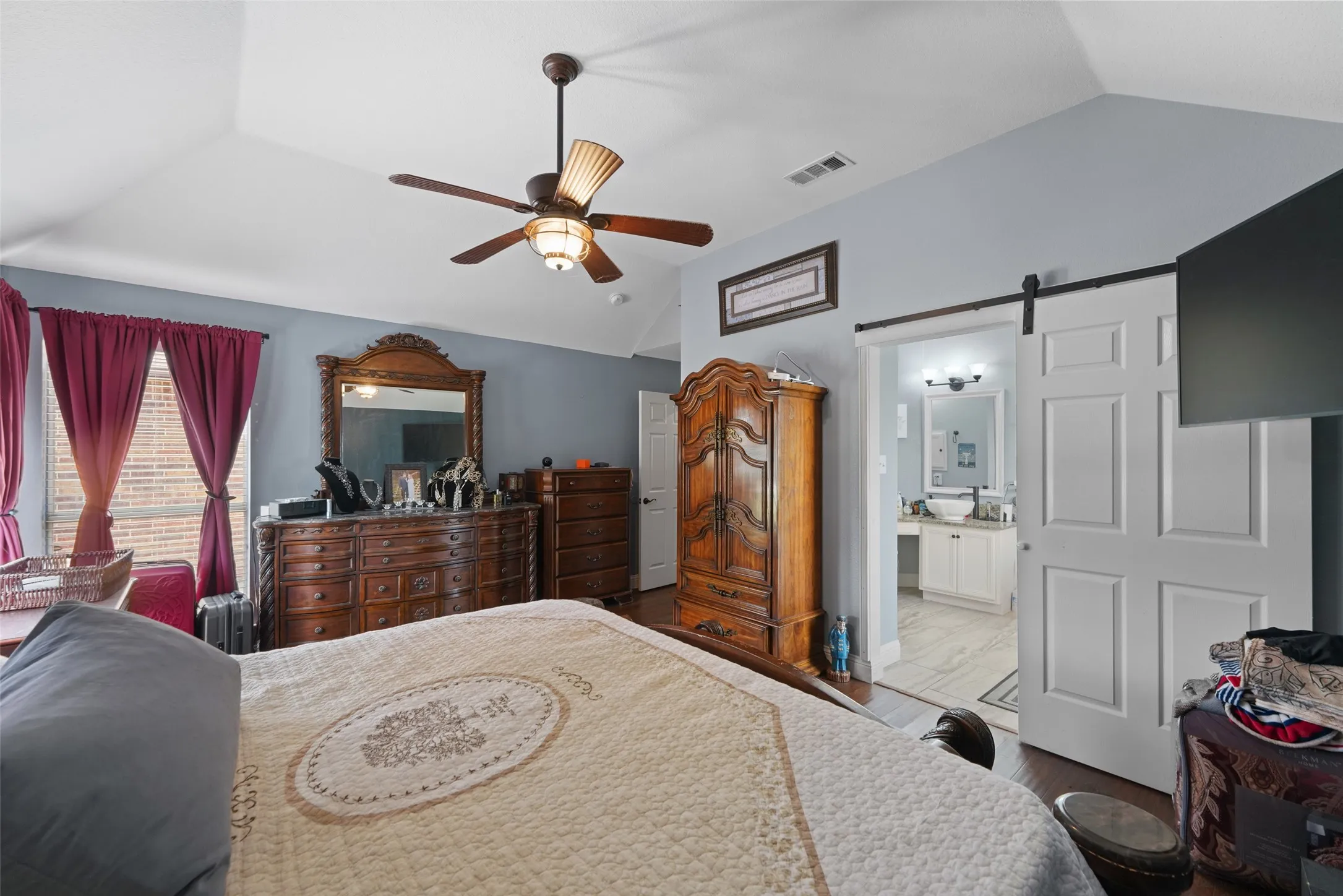 Bedroom featuring a vaulted ceiling and wood-finish flooring