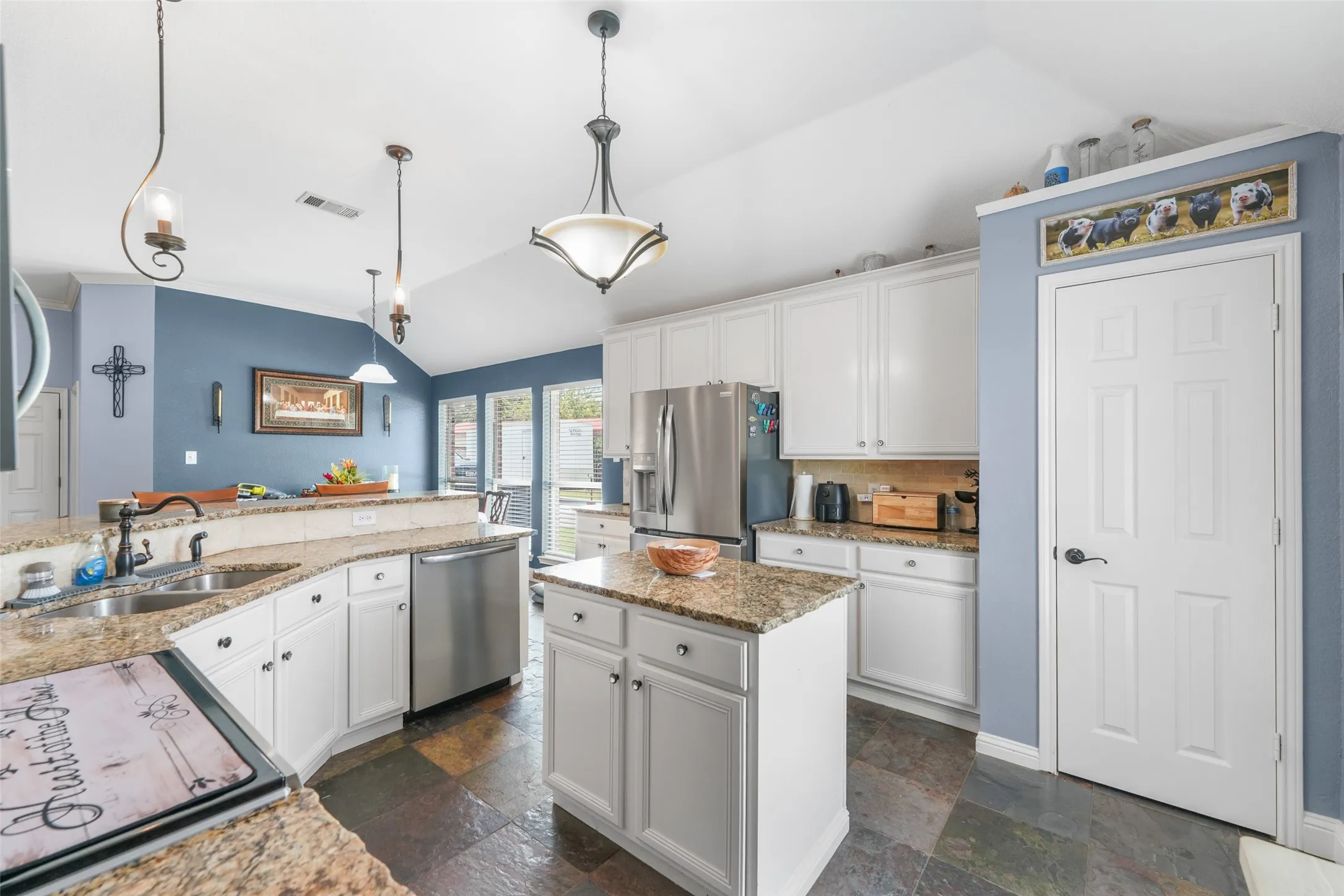 Kitchen featuring white cabinetry with brushed nickel hardware, granite countertops, an undermount sink with a gooseneck faucet, stainless steel appliances, and slate-finish flooring