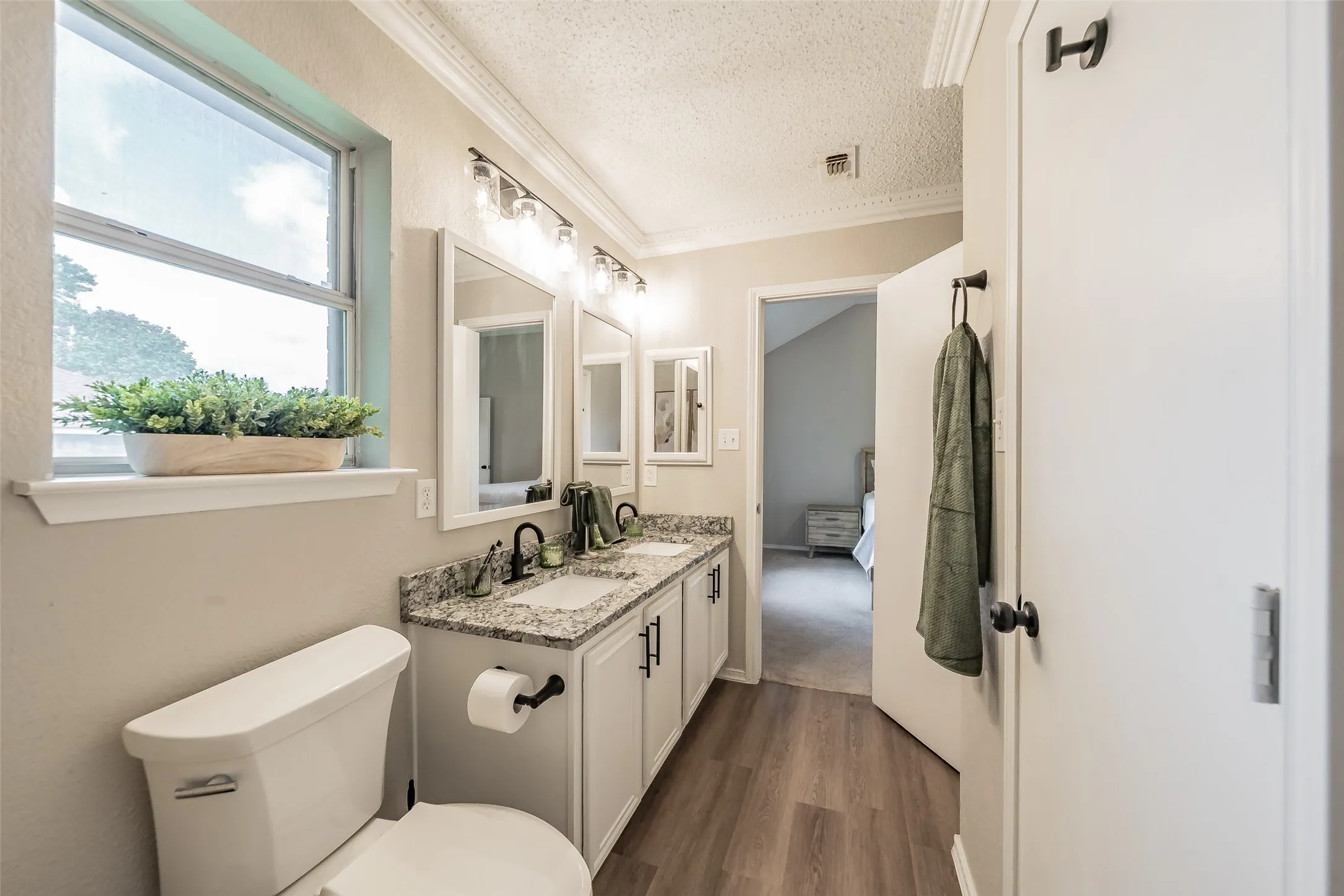 Bathroom featuring a double vanity with granite-style countertops, dual rectangular undermount sinks, and matte black faucets