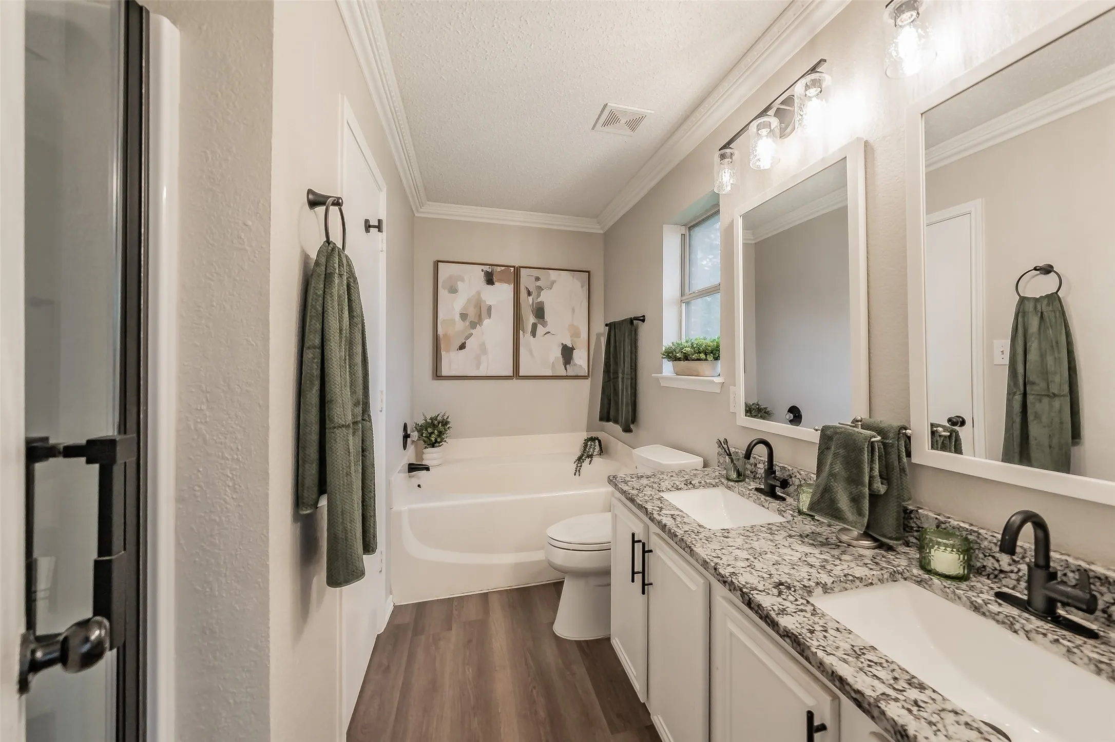 Primary Bath with double vanity featuring granite-style countertops, undermount sinks, and matte black fixtures