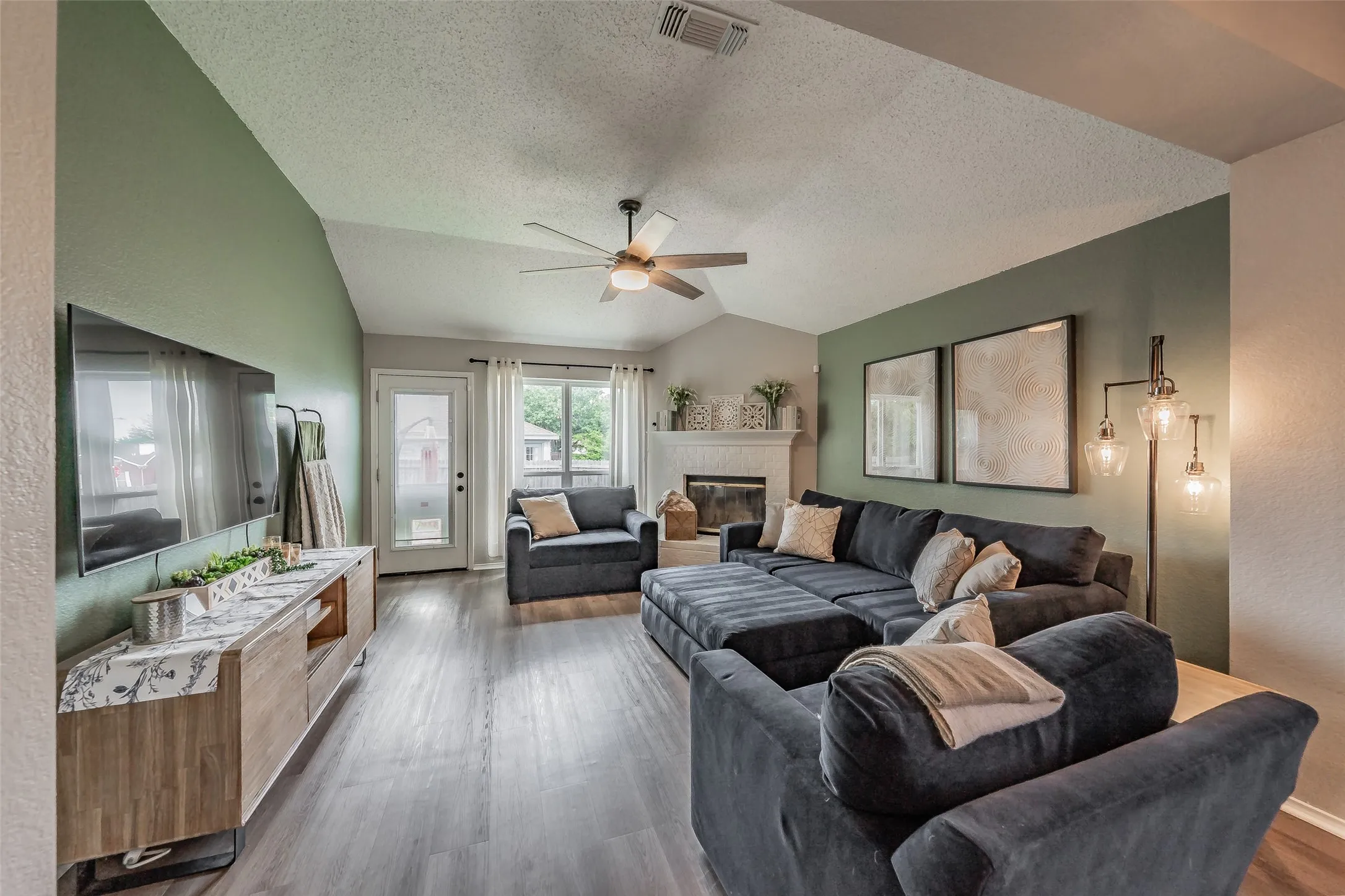 Living area featuring  a brick fireplace and hearth with a mantel