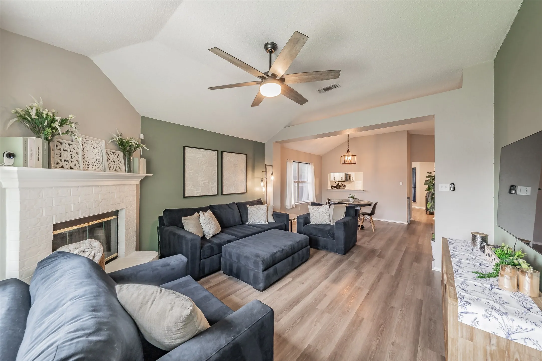 Spacious living area featuring a brick fireplace